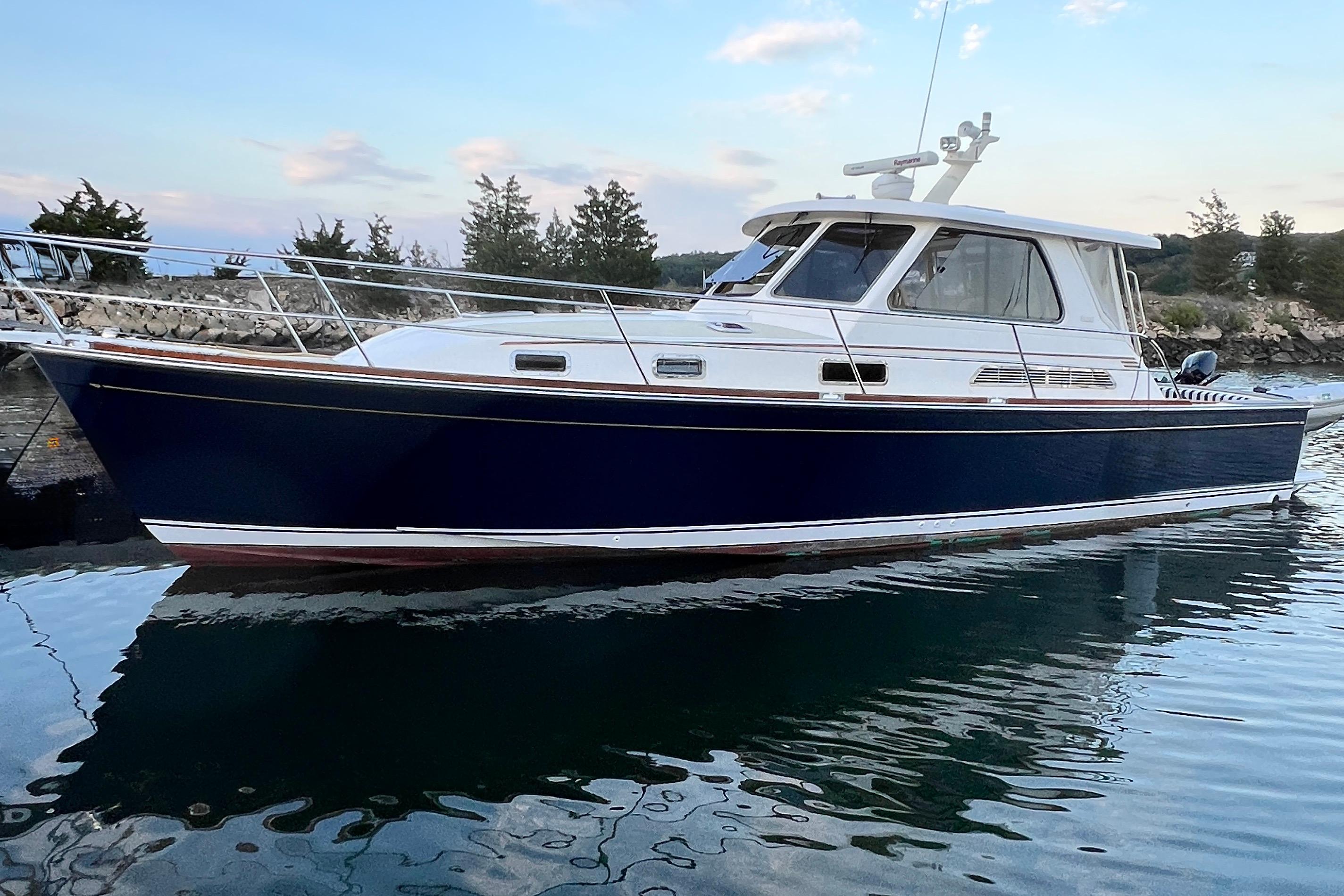 2006 Sabre 38 Hard Top Express boat on calm water, scenic background.