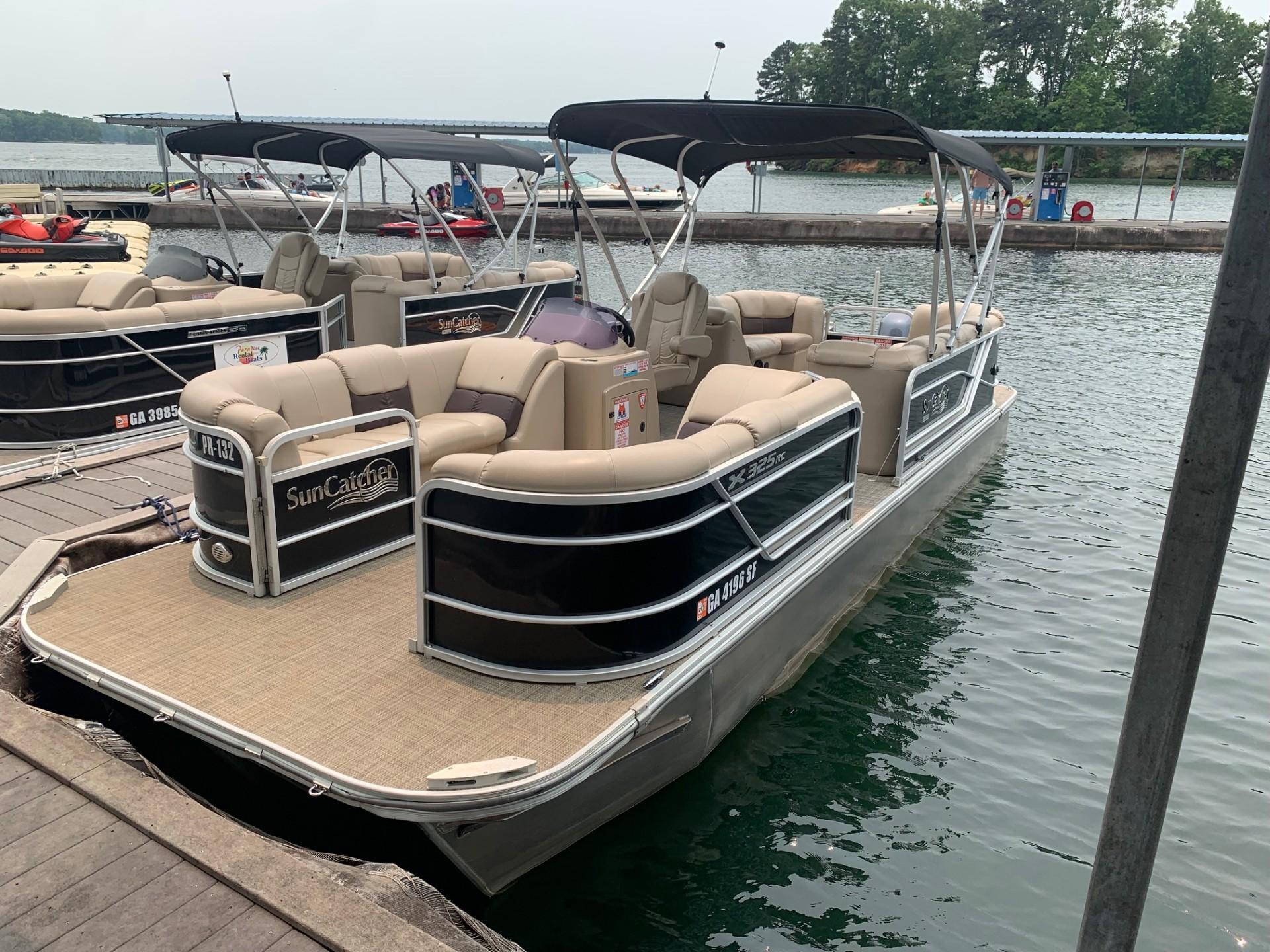 2021 G3 SunCatcher Fusion 325RCX pontoon boat docked on a calm lake.