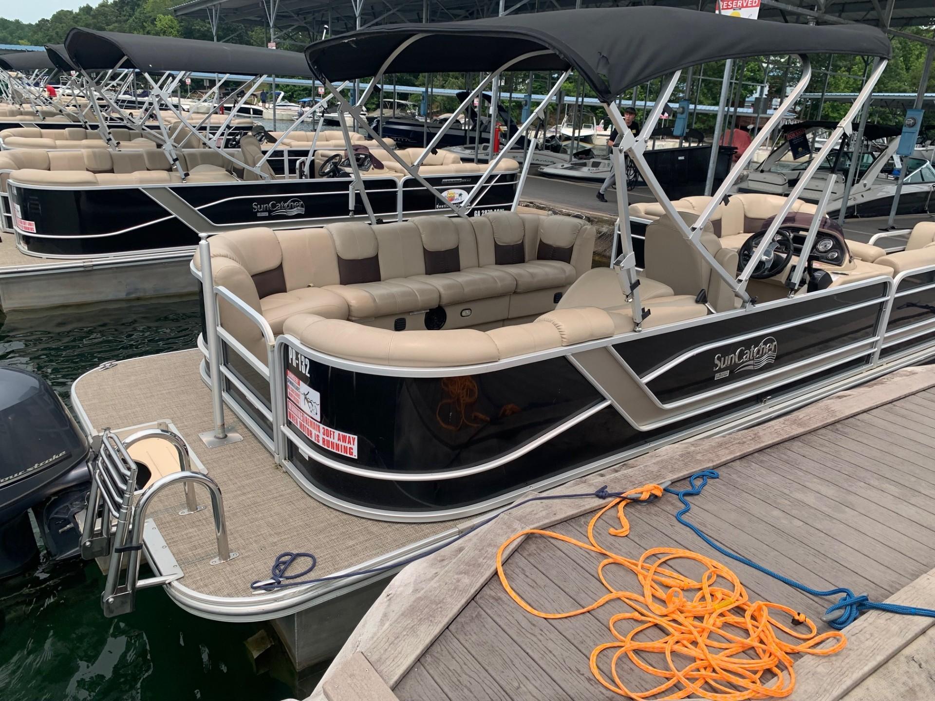 2021 G3 SunCatcher Fusion 325RCX pontoon boat docked with beige seating and canopy.