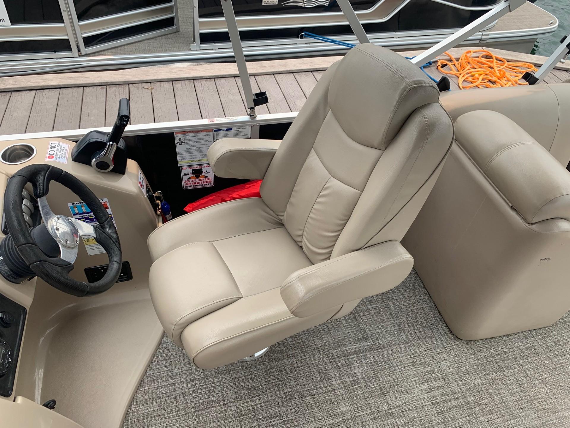 Captain's chair on 2021 G3 SunCatcher Fusion 325RCX pontoon boat, beige upholstery, steering wheel visible.