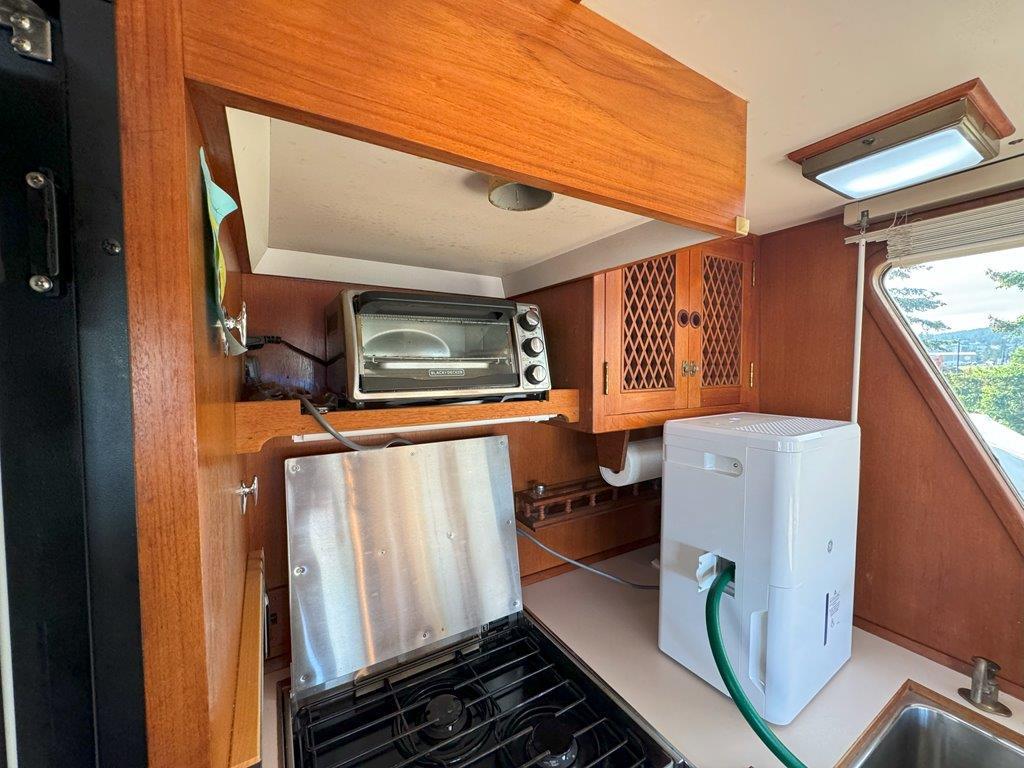 Ocean Alexander-50 MK1 1980 -WA-US-Galley kitchen in 1980 Ocean Alexander 50 MK1 yacht with appliances and wooden cabinetry.-9725618 | Thumbnail