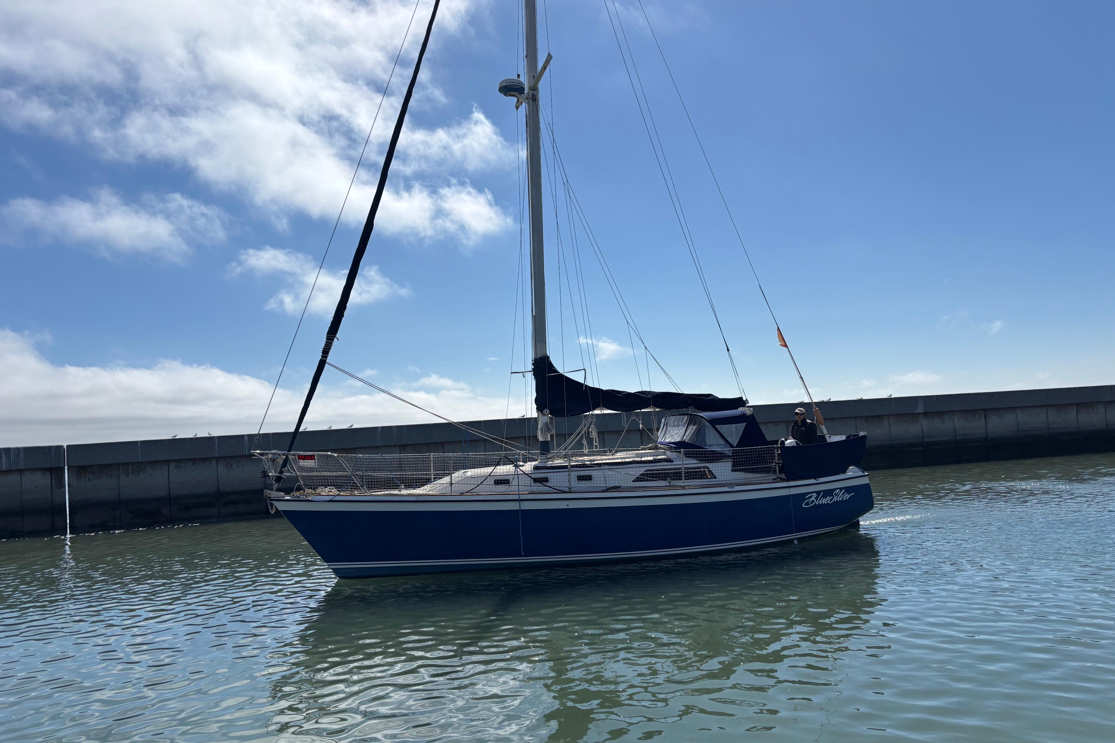 1981 O'Day 34 sailboat on calm water under a clear blue sky.