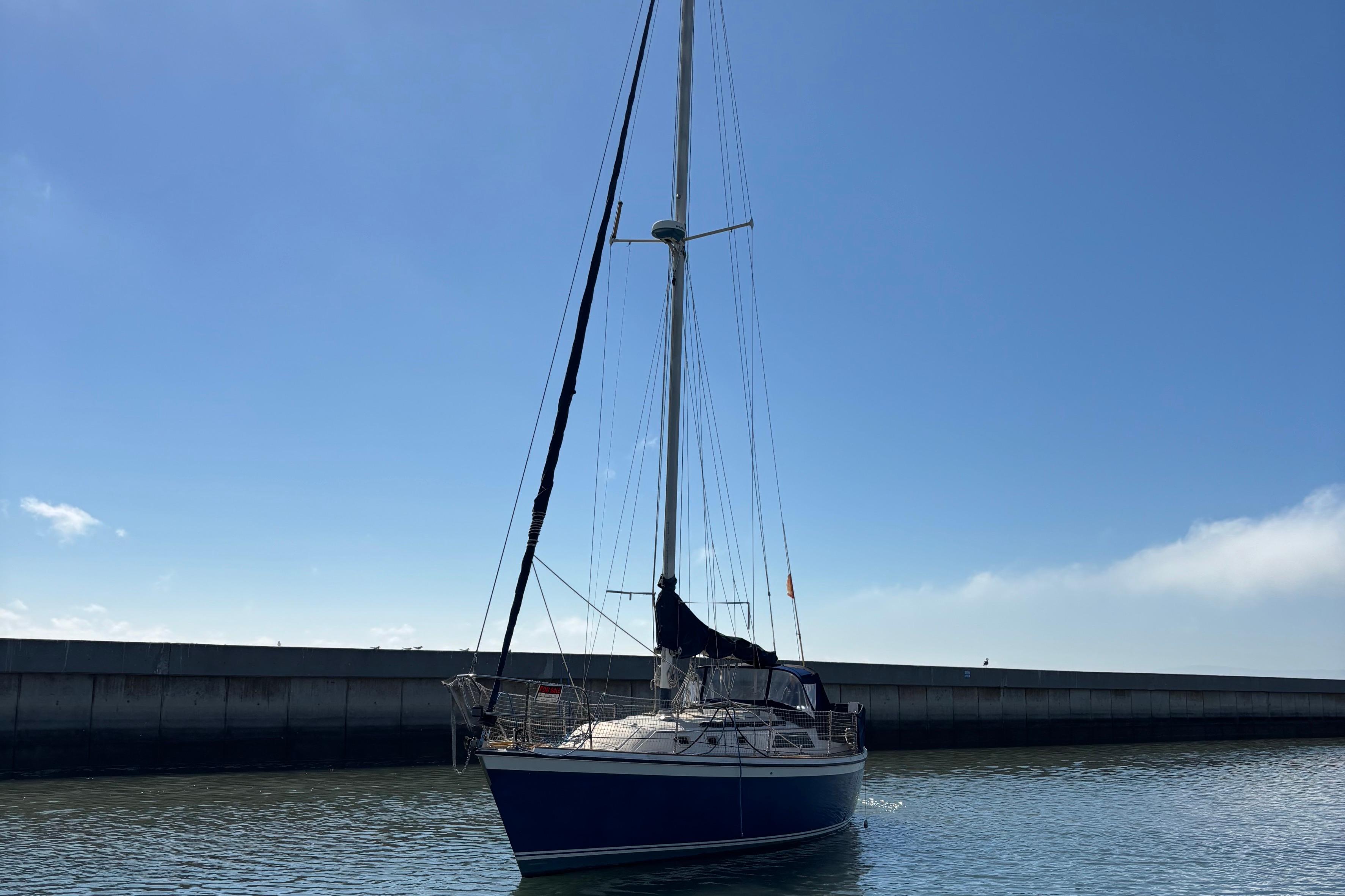 1981 O'Day 34 sailboat docked in calm waters under a clear blue sky.