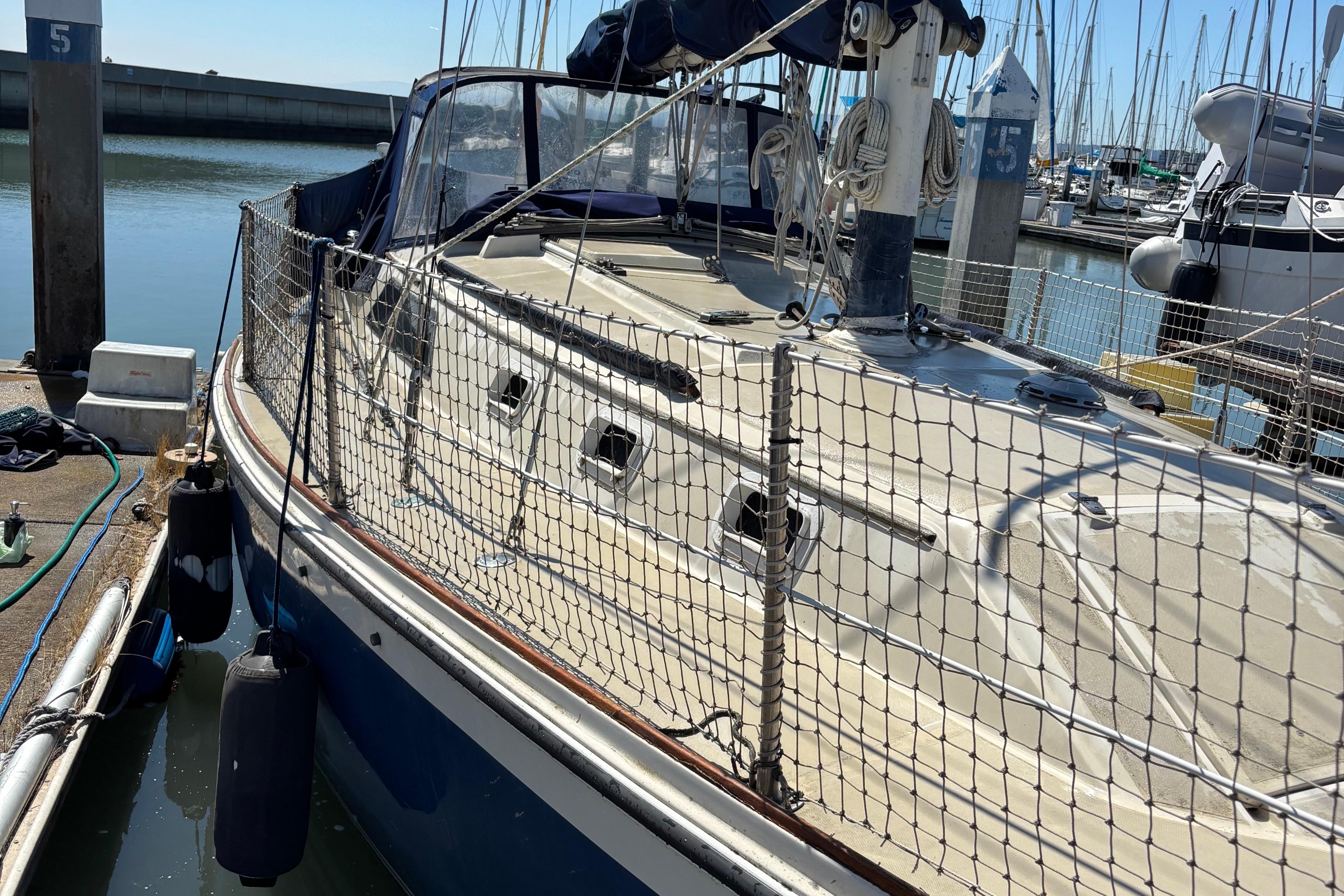 1981 O'Day 34 sailboat docked at marina, featuring netted safety lines and clean deck.