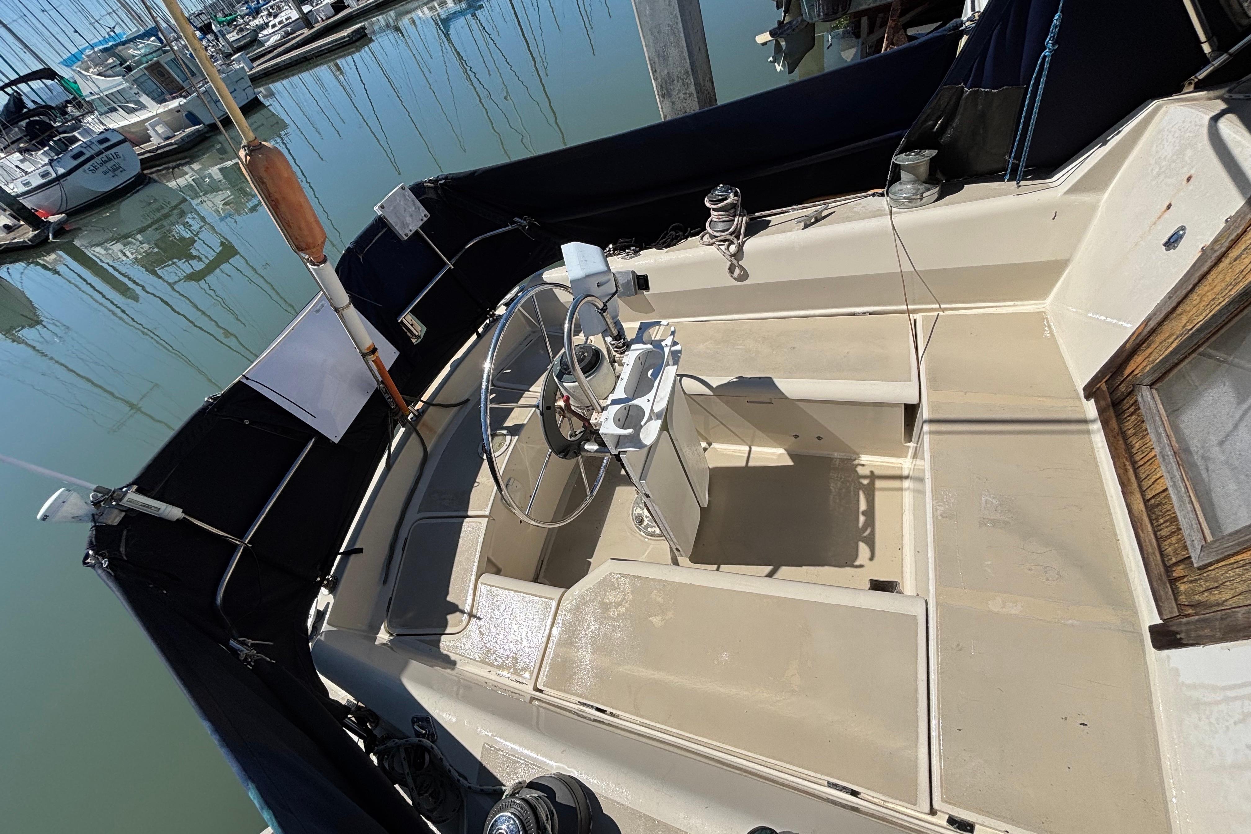 1981 O'Day 34 sailboat cockpit with steering wheel, docked at marina.