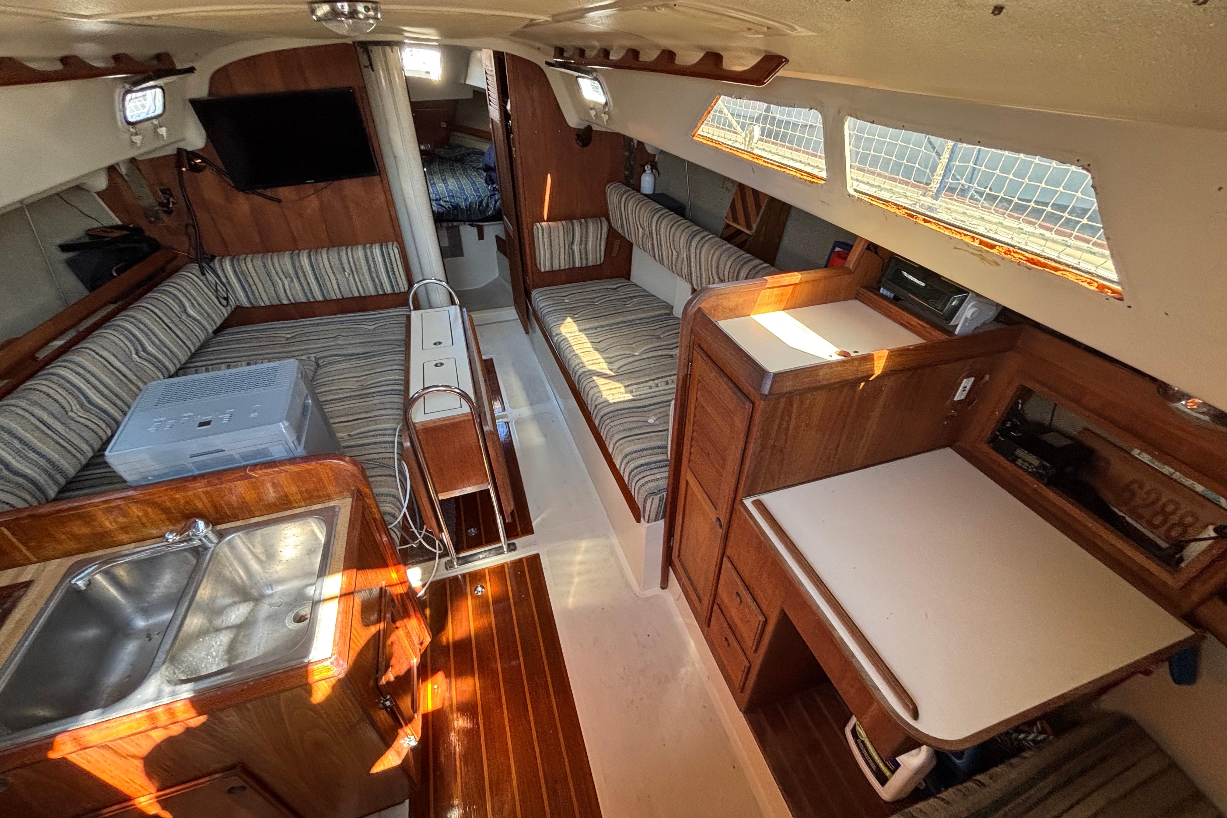 Interior of 1981 O'Day 34 sailboat with wood finishes and striped upholstery.