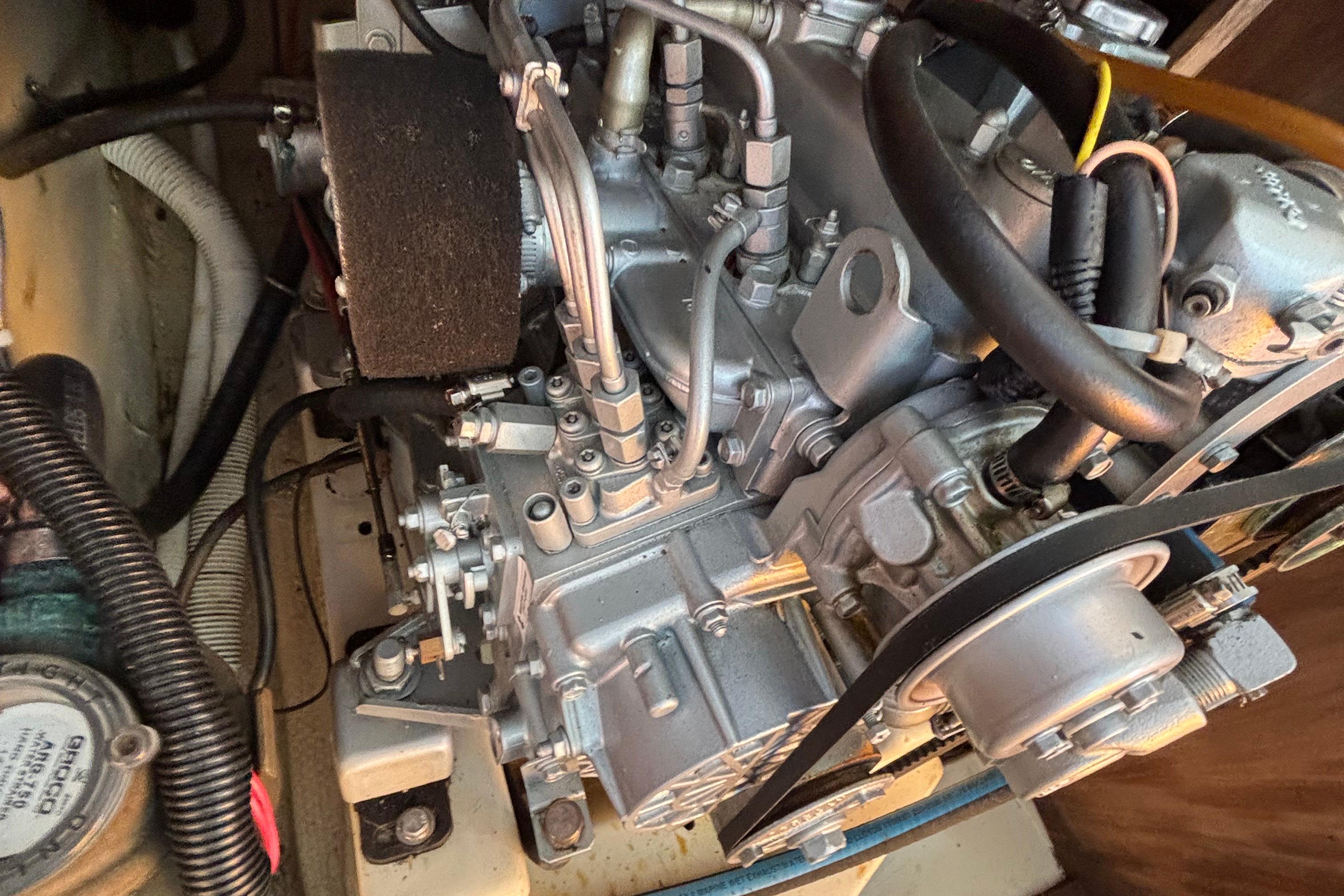 Engine compartment of a 1981 O'Day 34 sailboat, showcasing mechanical components and wiring.