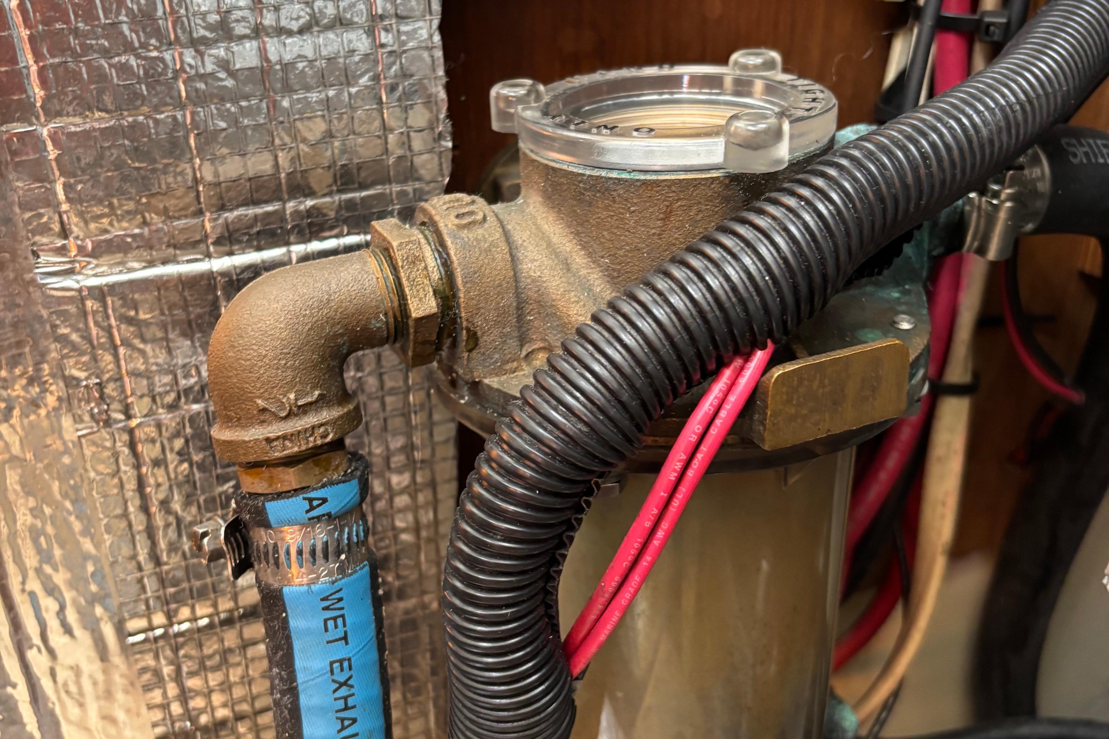 Engine compartment of a 1981 O'Day 34 sailboat, showing exhaust and wiring.