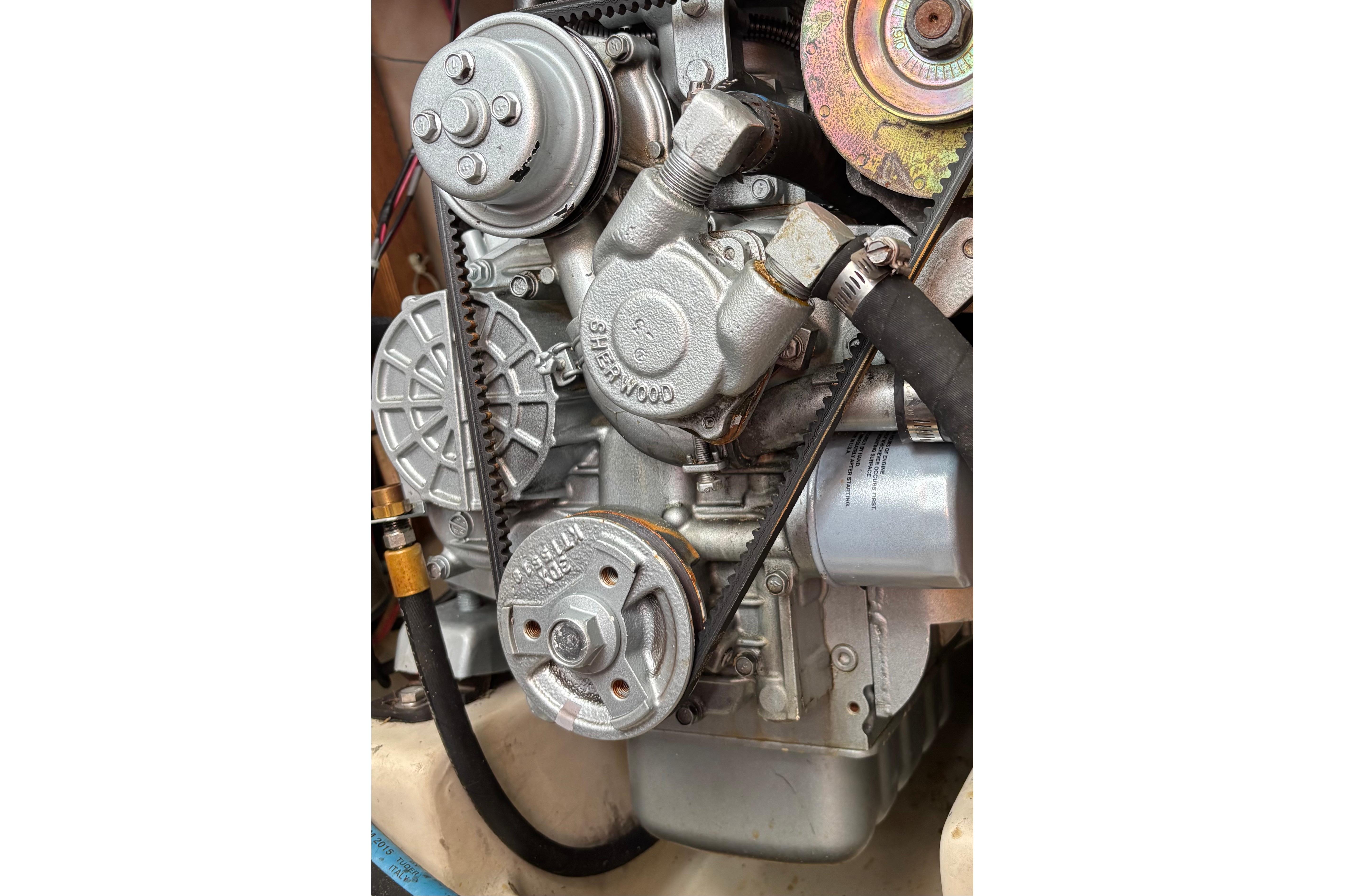 Close-up of a 1981 O'Day 34 engine, showcasing mechanical components and belts.