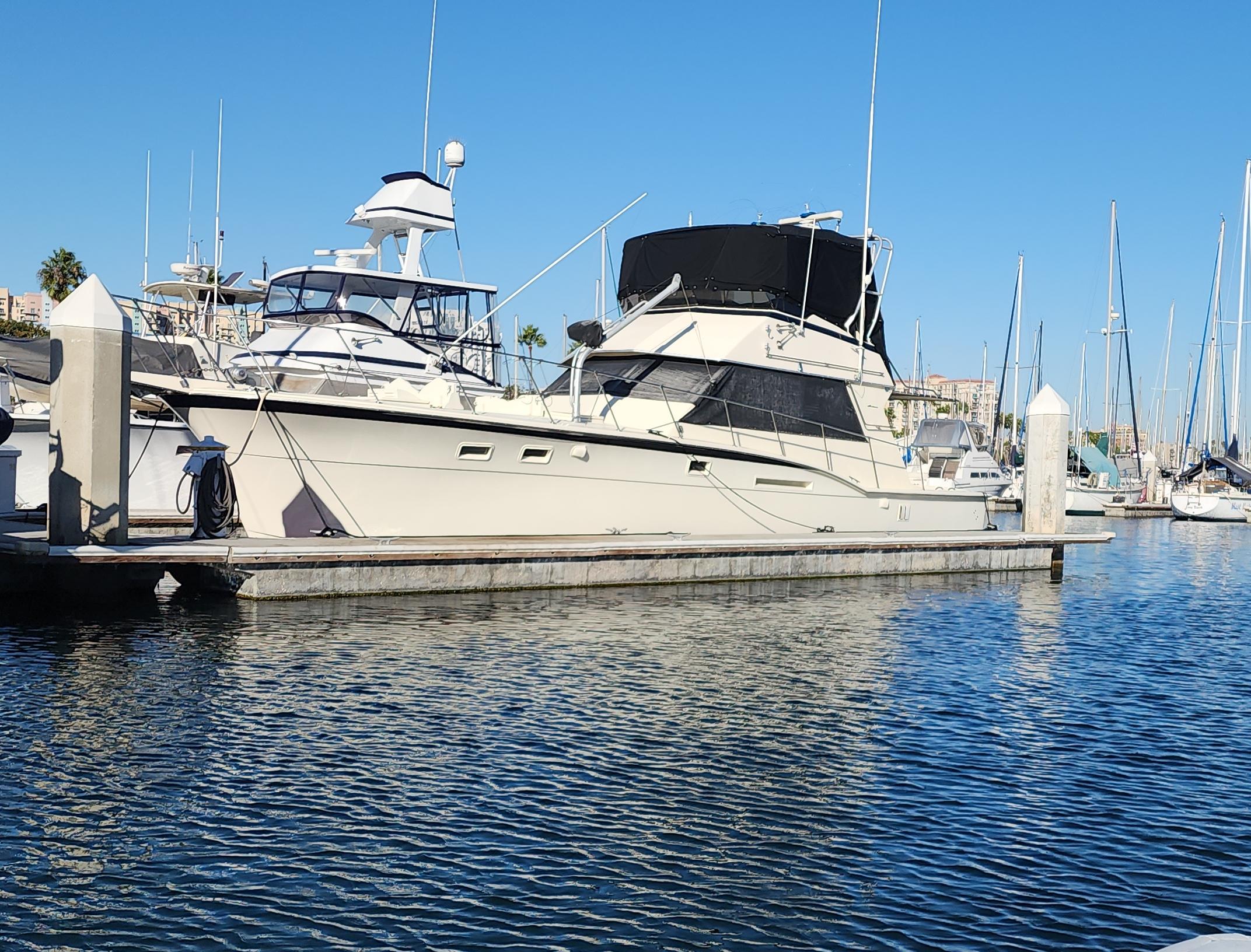 1978 Hatteras Sportfish yacht docked in a marina under clear blue skies.