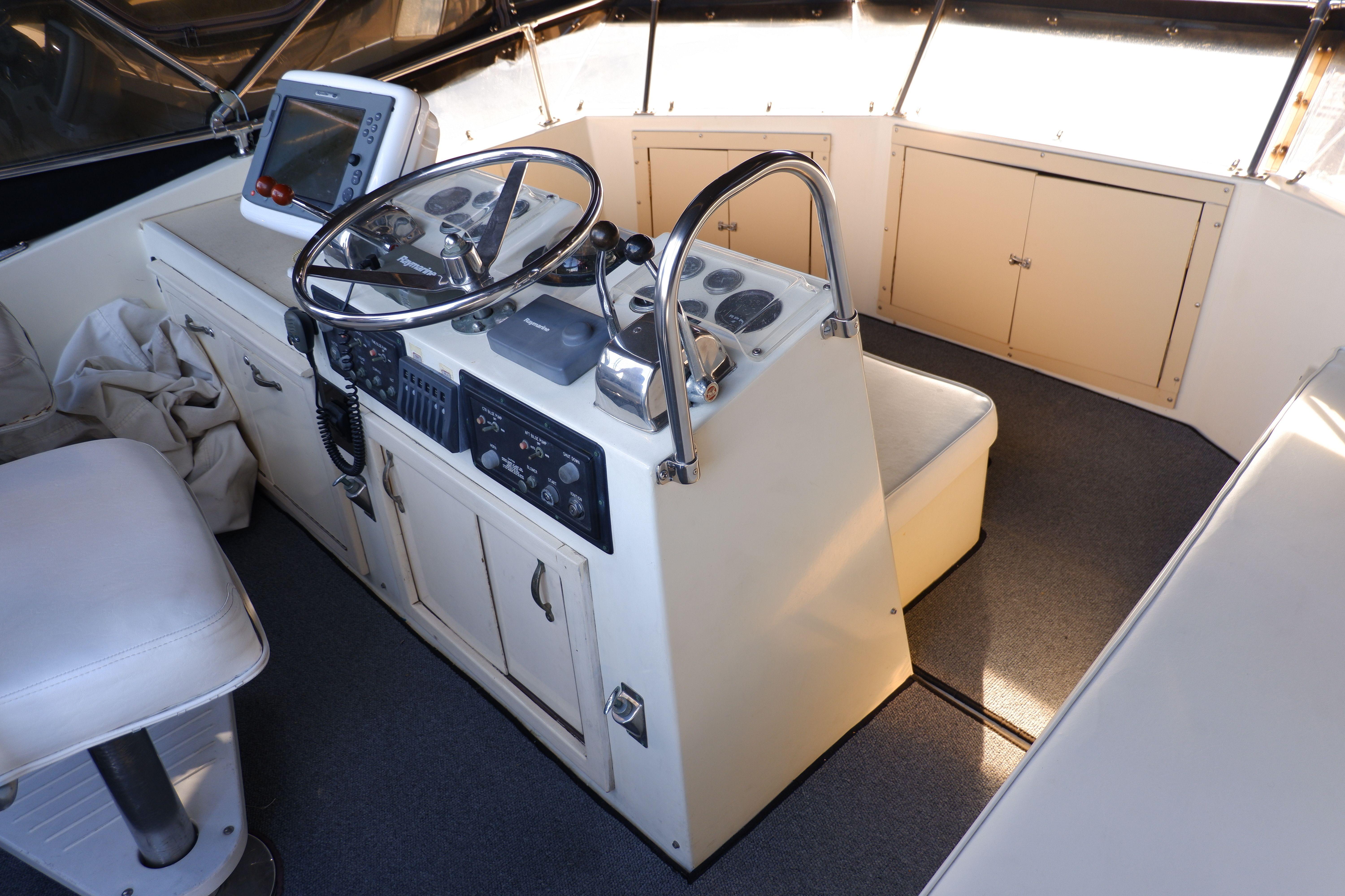 1978 Hatteras Sportfish helm with steering wheel, navigation equipment, and seating.