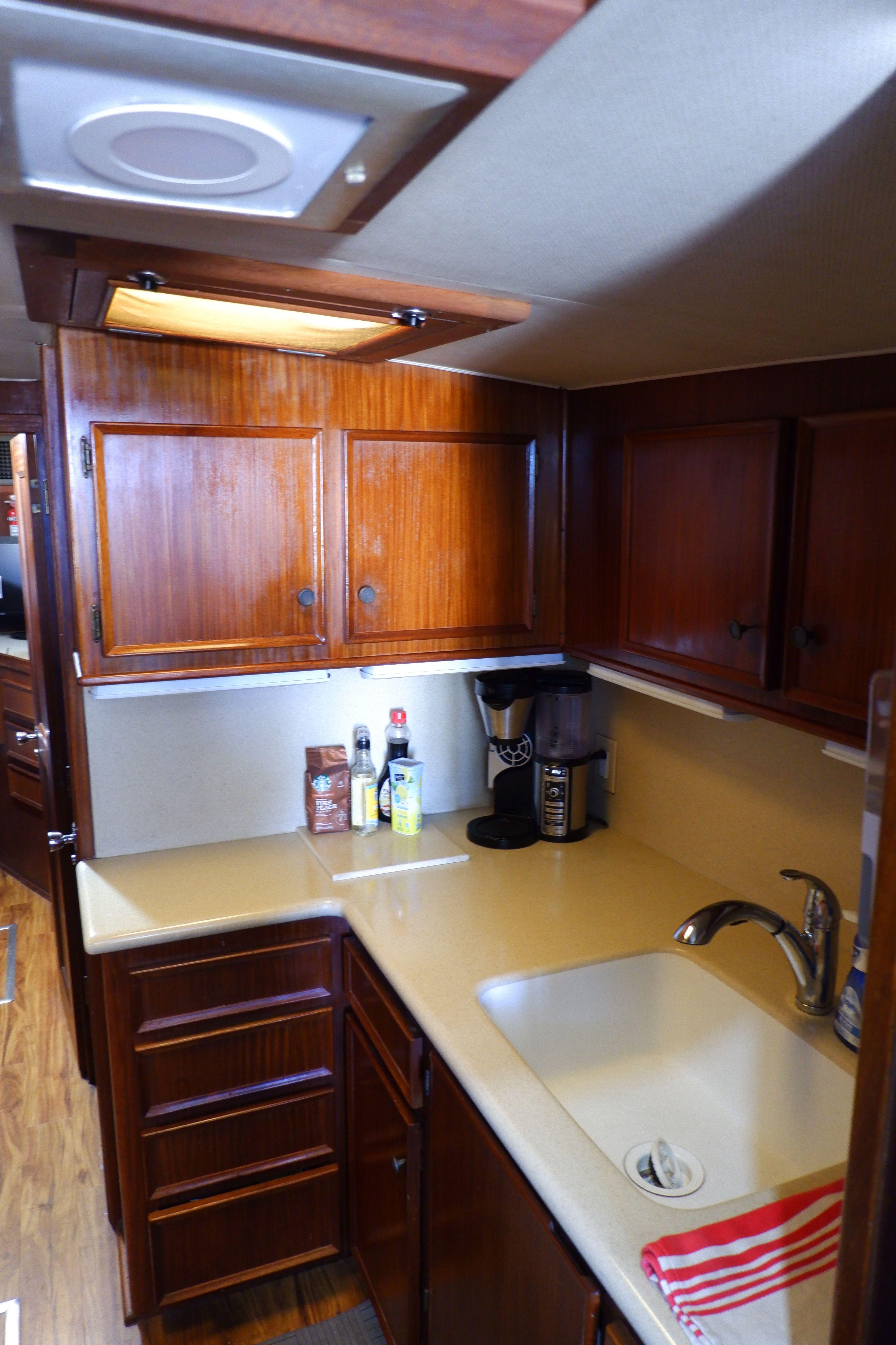 1978 Hatteras Sportfish kitchen with wooden cabinets, sink, and countertop appliances.