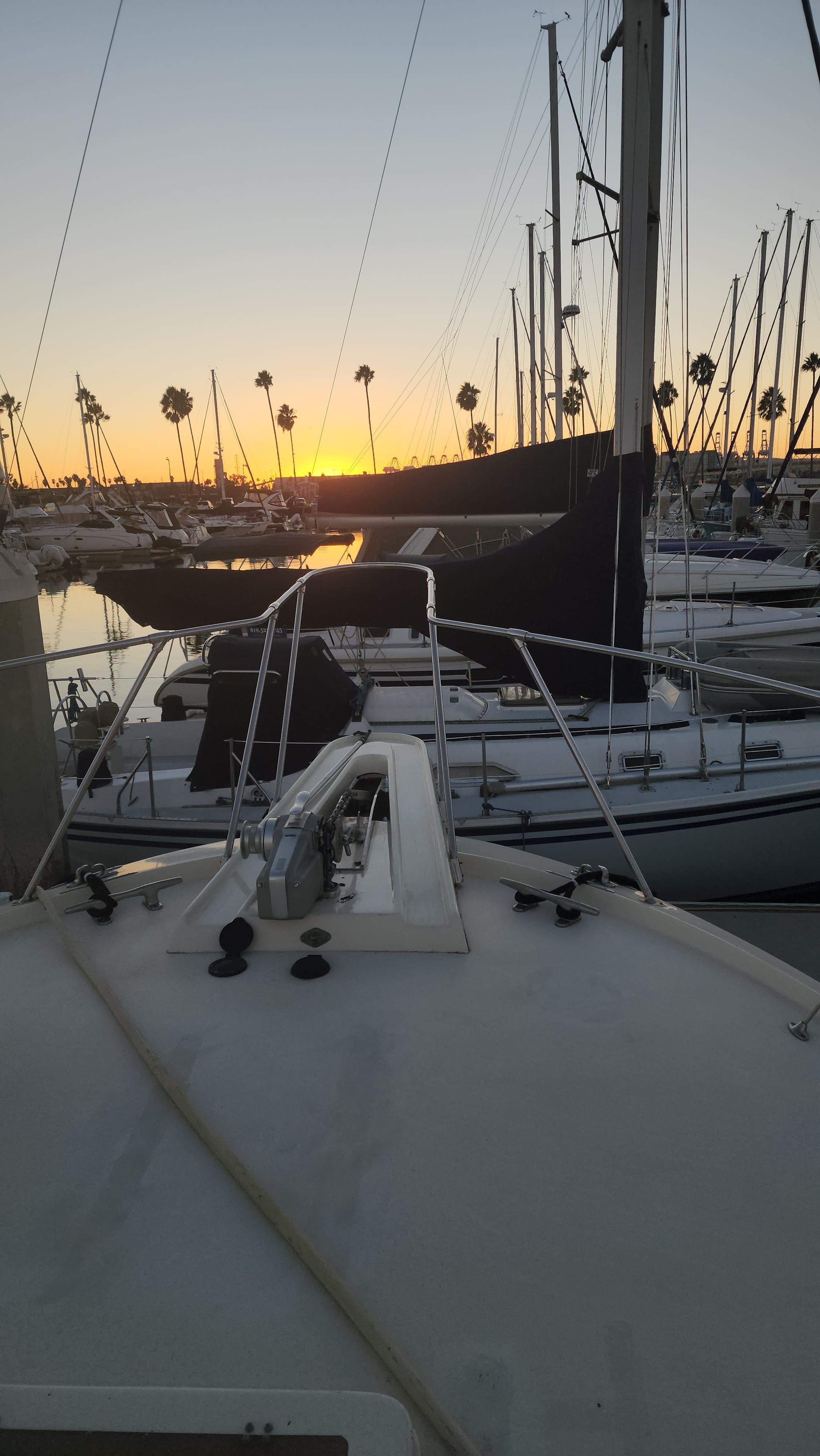 1978 Hatteras Sportfish yacht at sunset in marina with sailboats.