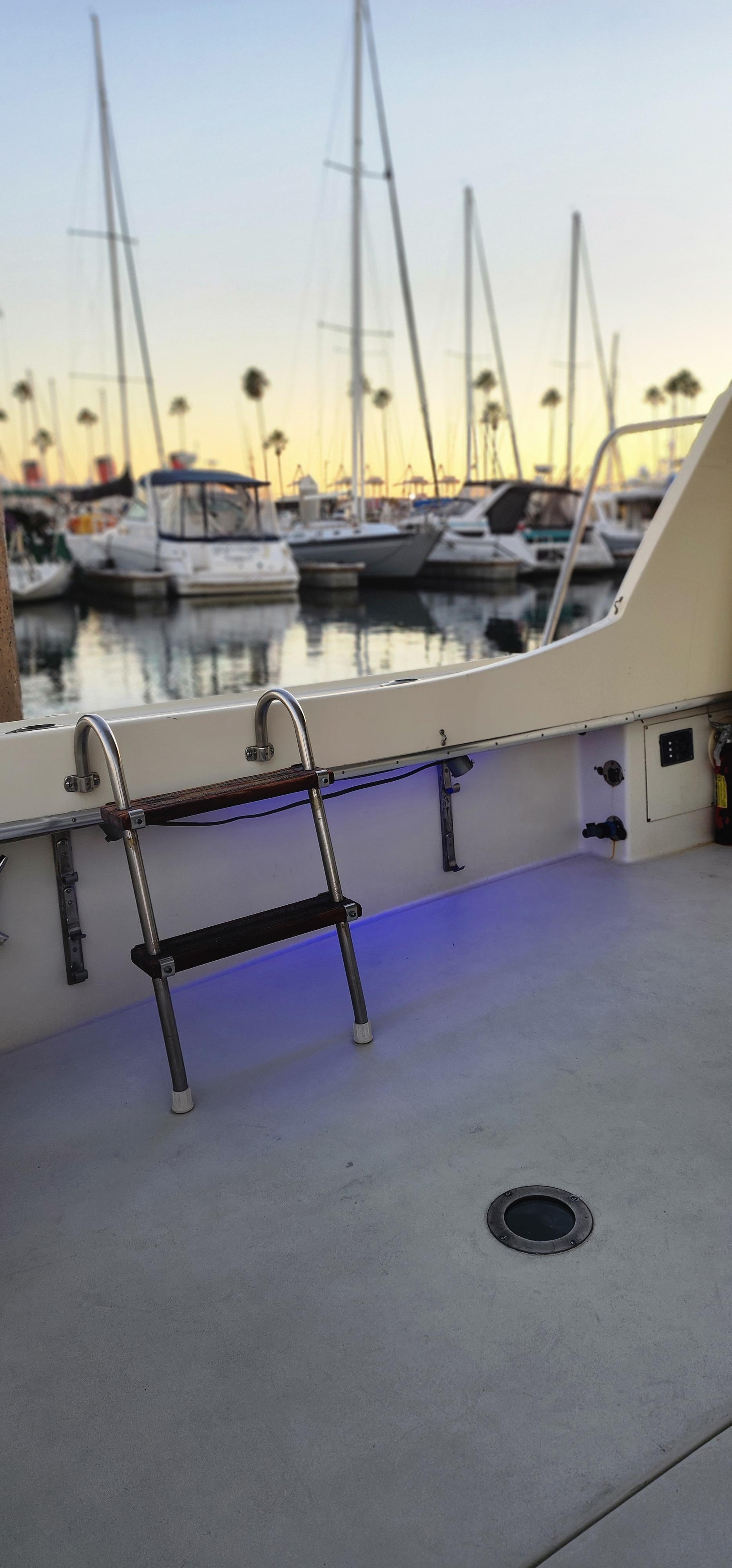 1978 Hatteras Sportfish boat docked at marina with sunset view.
