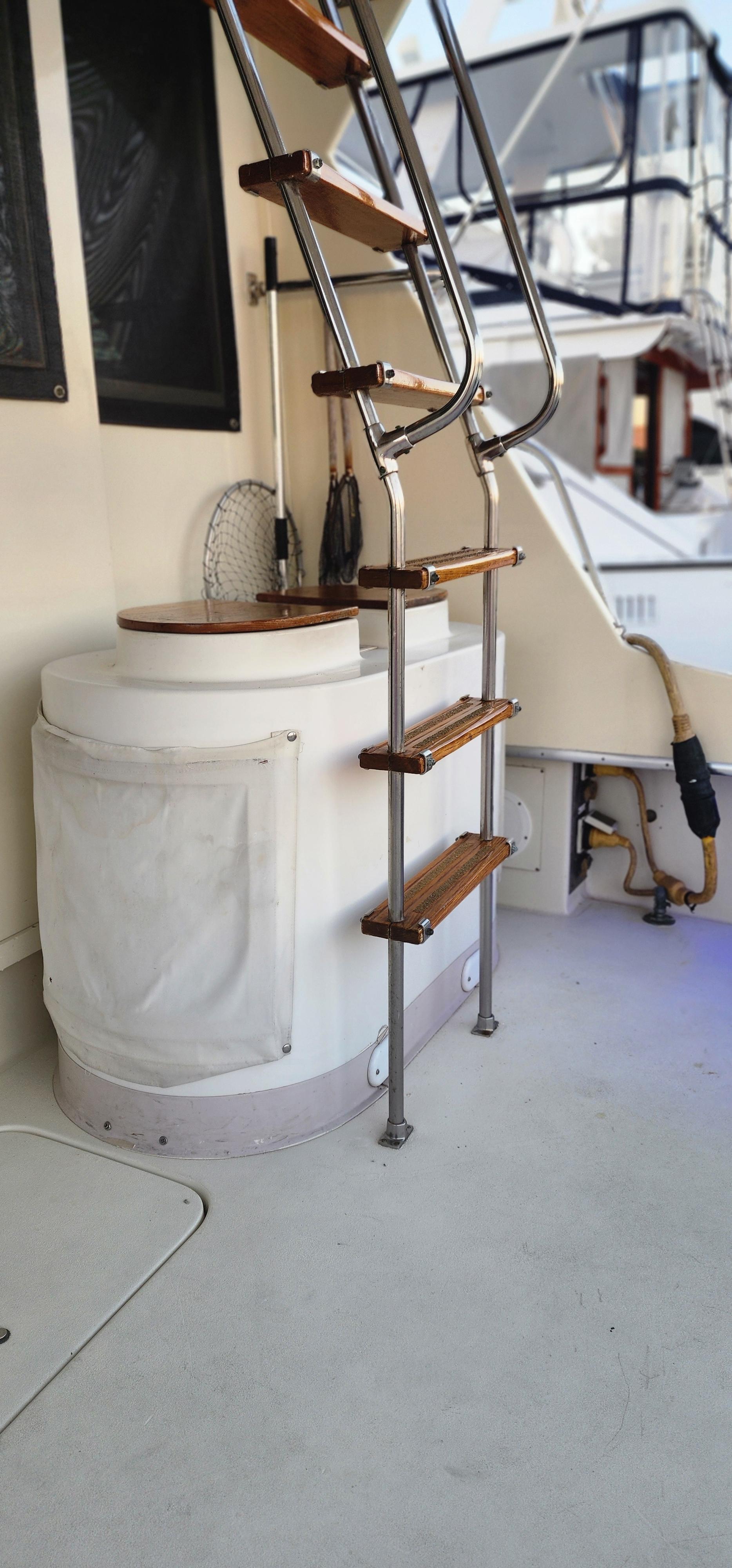 1978 Hatteras Sportfish boat interior with wooden stairs and fishing gear.