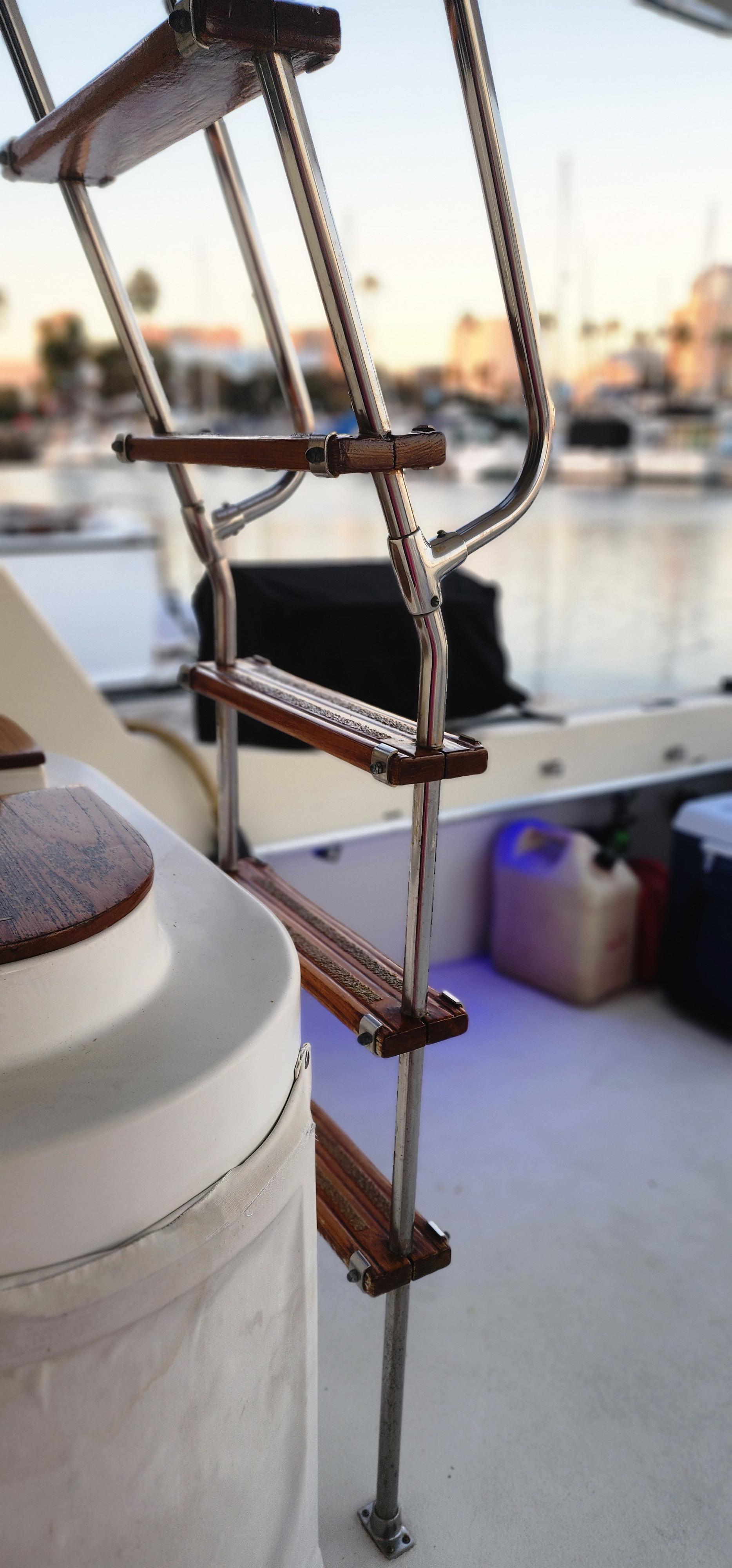 Staircase on 1978 Hatteras Sportfish yacht with marina background.