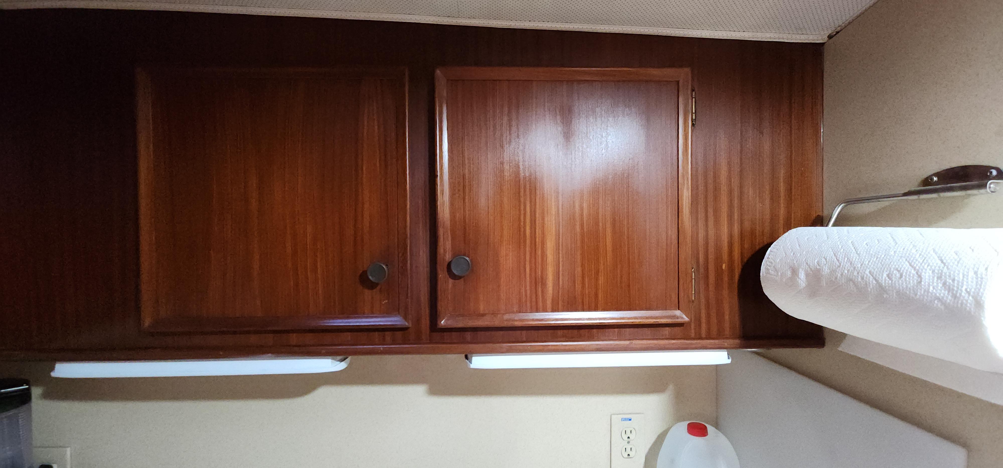 1978 Hatteras Sportfish interior with wooden cabinets and paper towel holder.