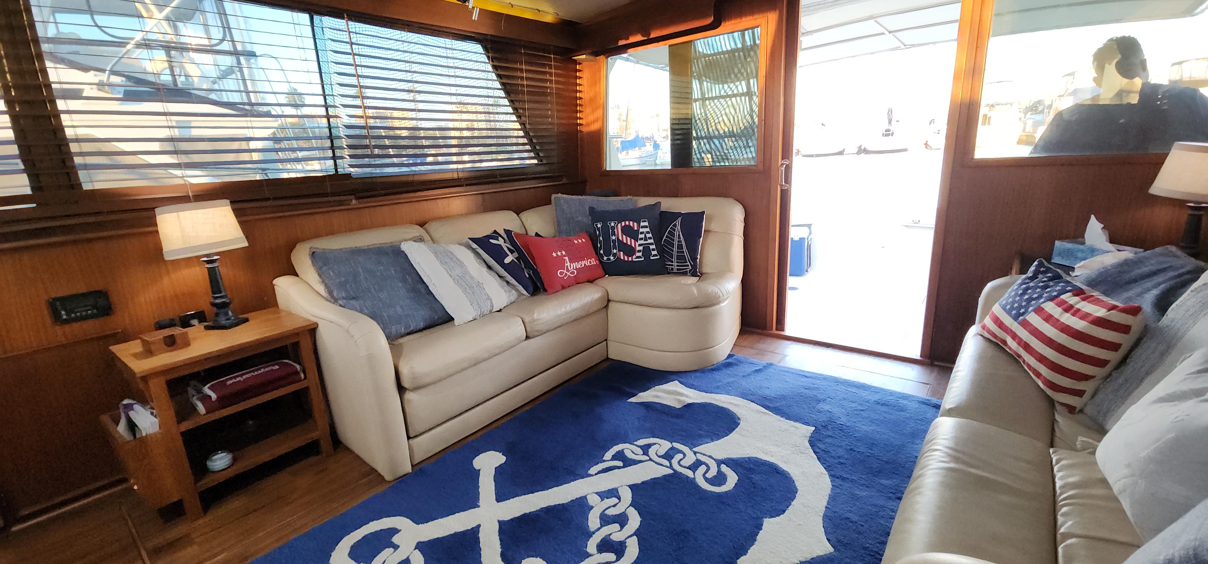 Interior of a 1978 Hatteras Sportfish yacht with nautical-themed decor and comfortable seating.