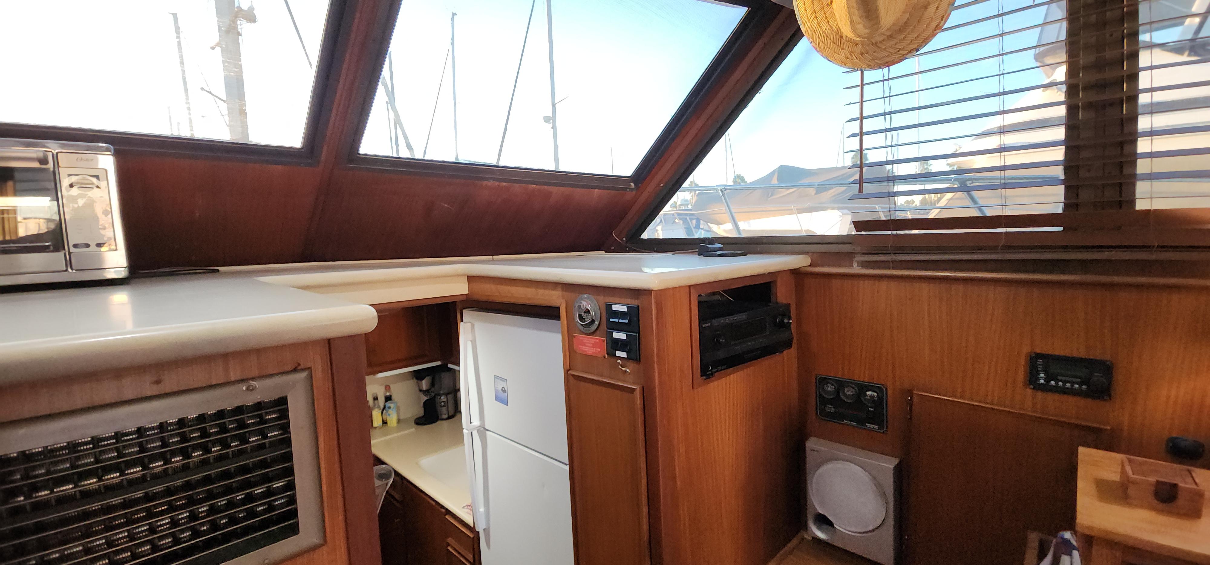 1978 Hatteras Sportfish interior with wood paneling, appliances, and large windows.