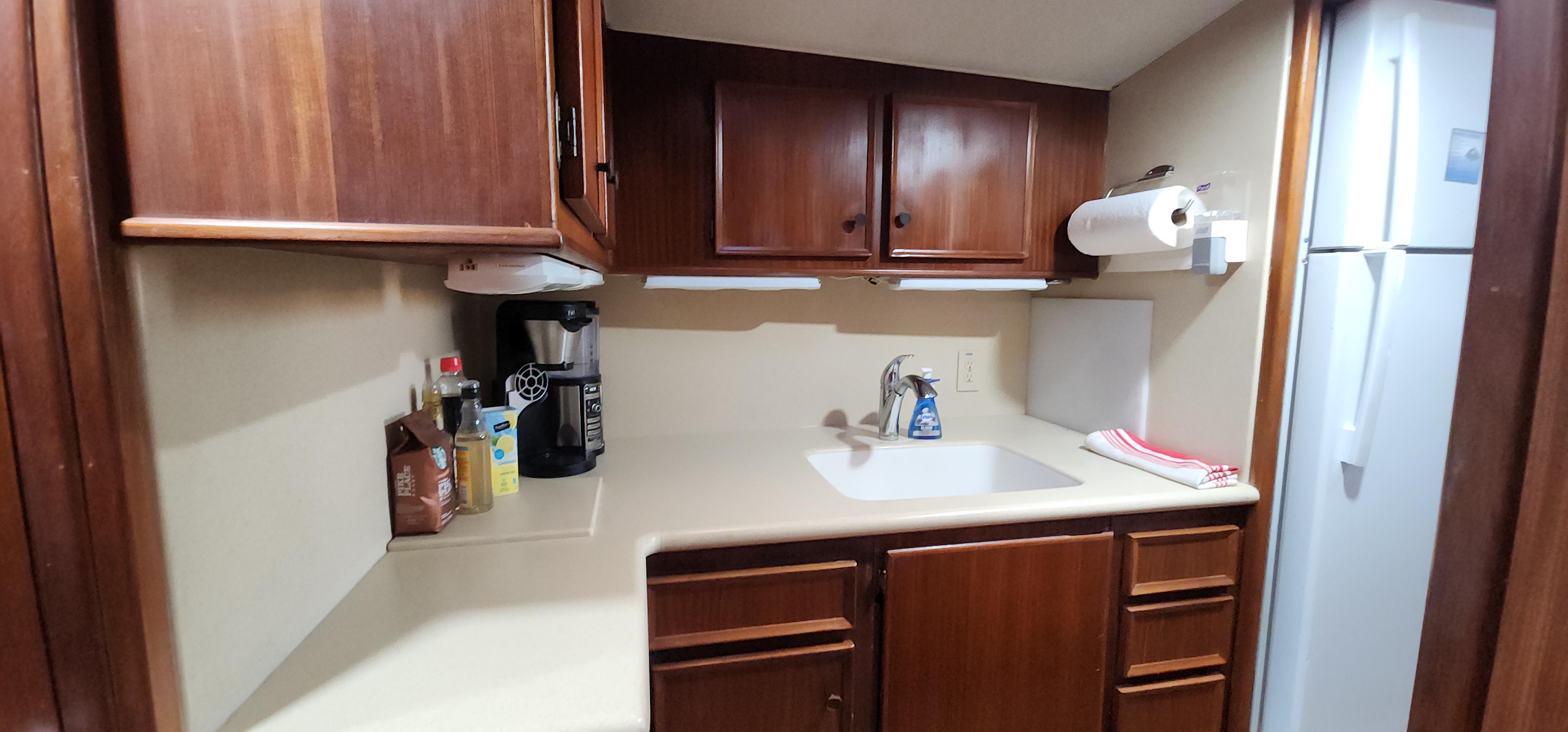 1978 Hatteras Sportfish kitchen with wooden cabinets, sink, and appliances.