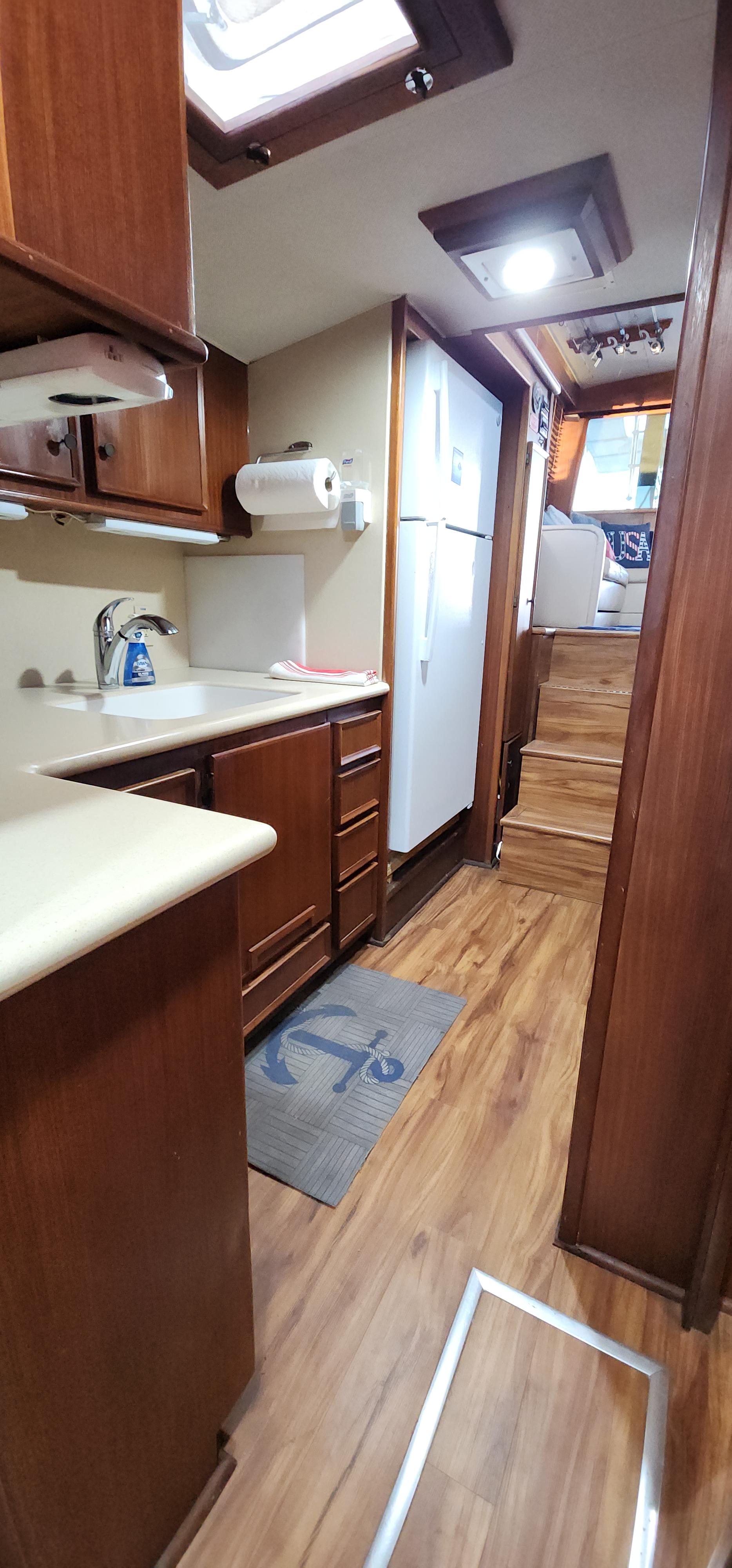 1978 Hatteras Sportfish interior kitchen with wood cabinets and flooring.