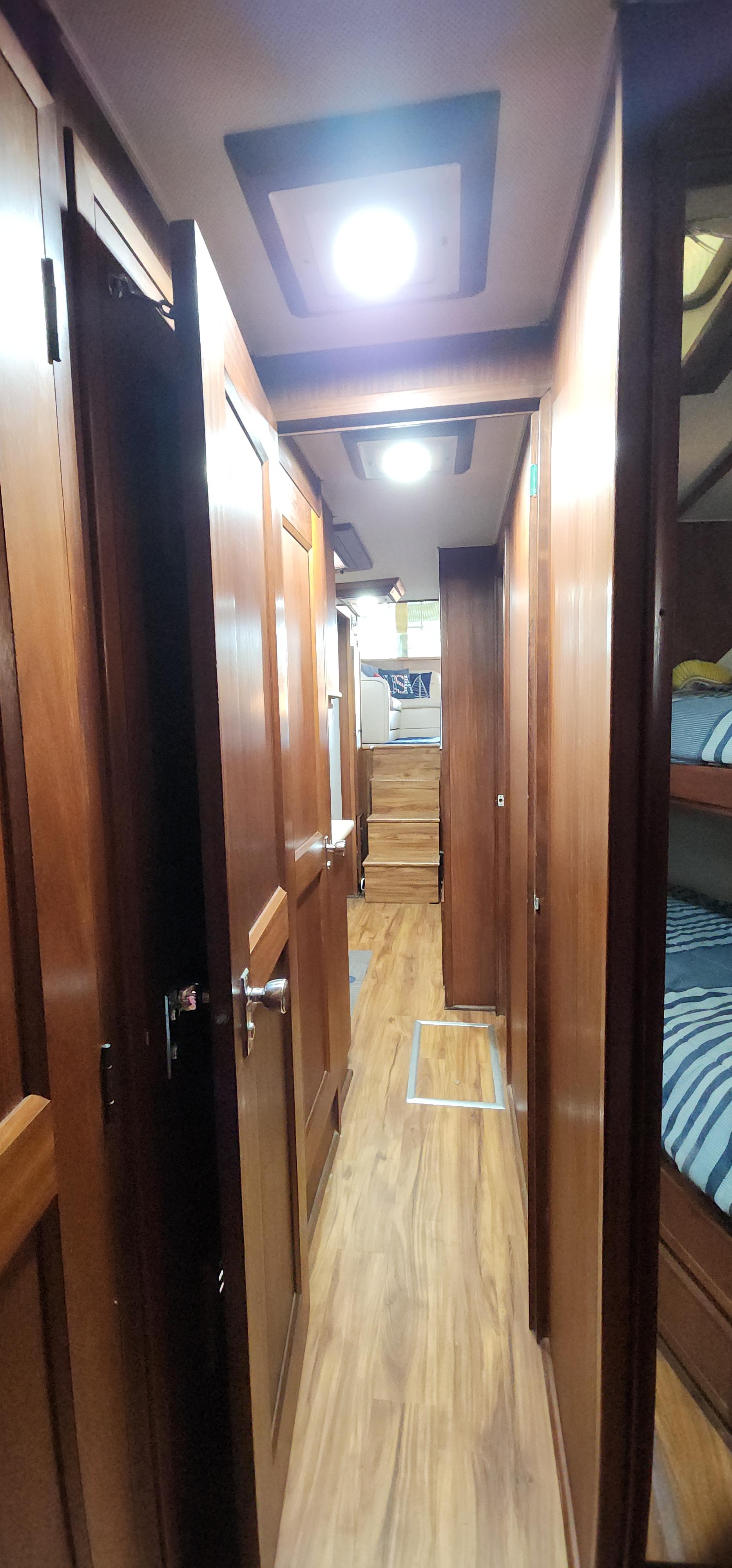 Interior hallway of a 1978 Hatteras Sportfish yacht with wooden finishes and bunk beds.