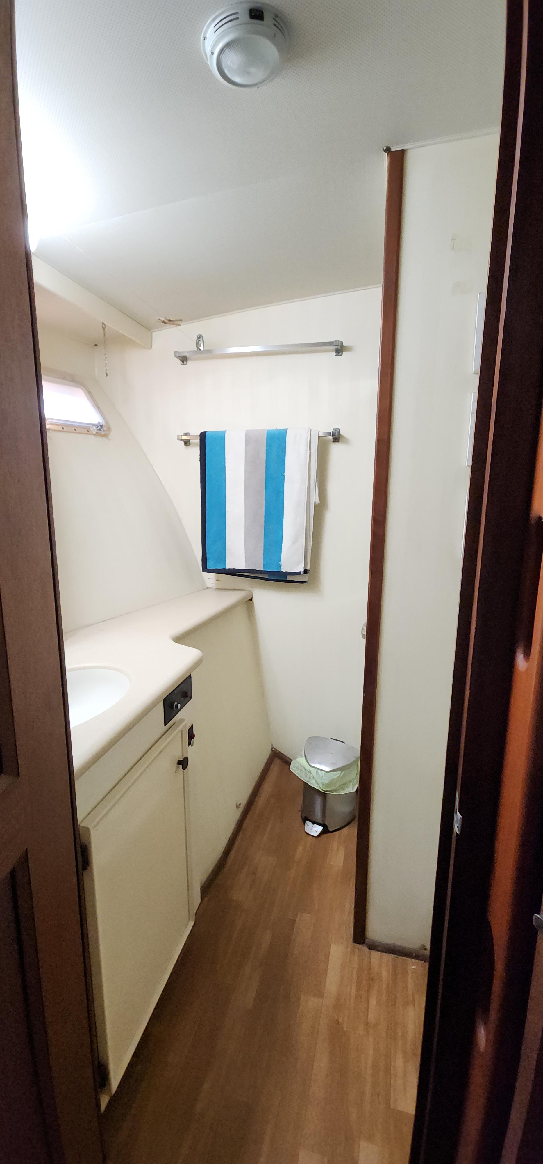 1978 Hatteras Sportfish bathroom with wood flooring and striped towel.