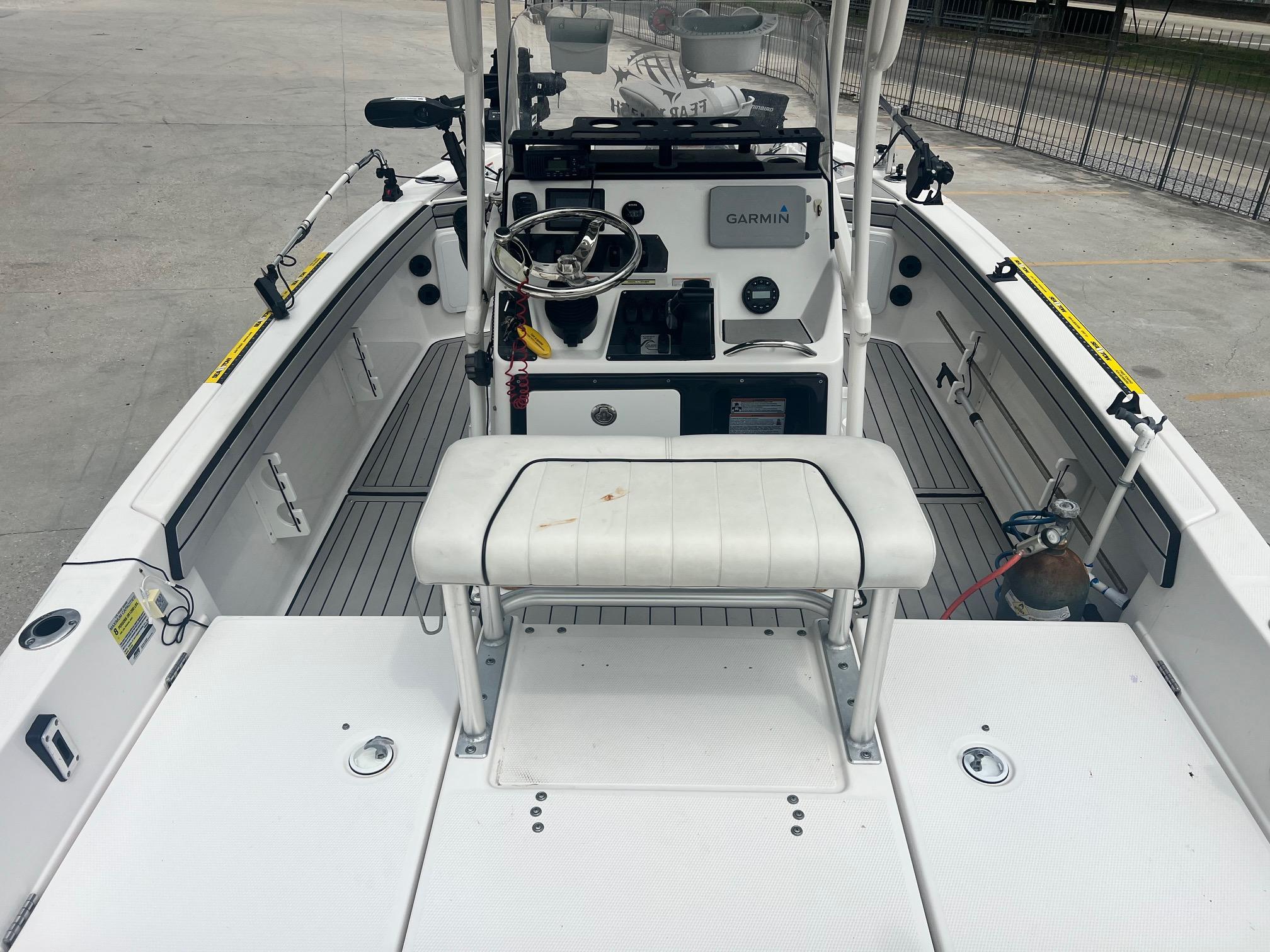 2020 Yamaha Boats 195 FSH Sport interior with Garmin system, white seating, and fishing rod holders.