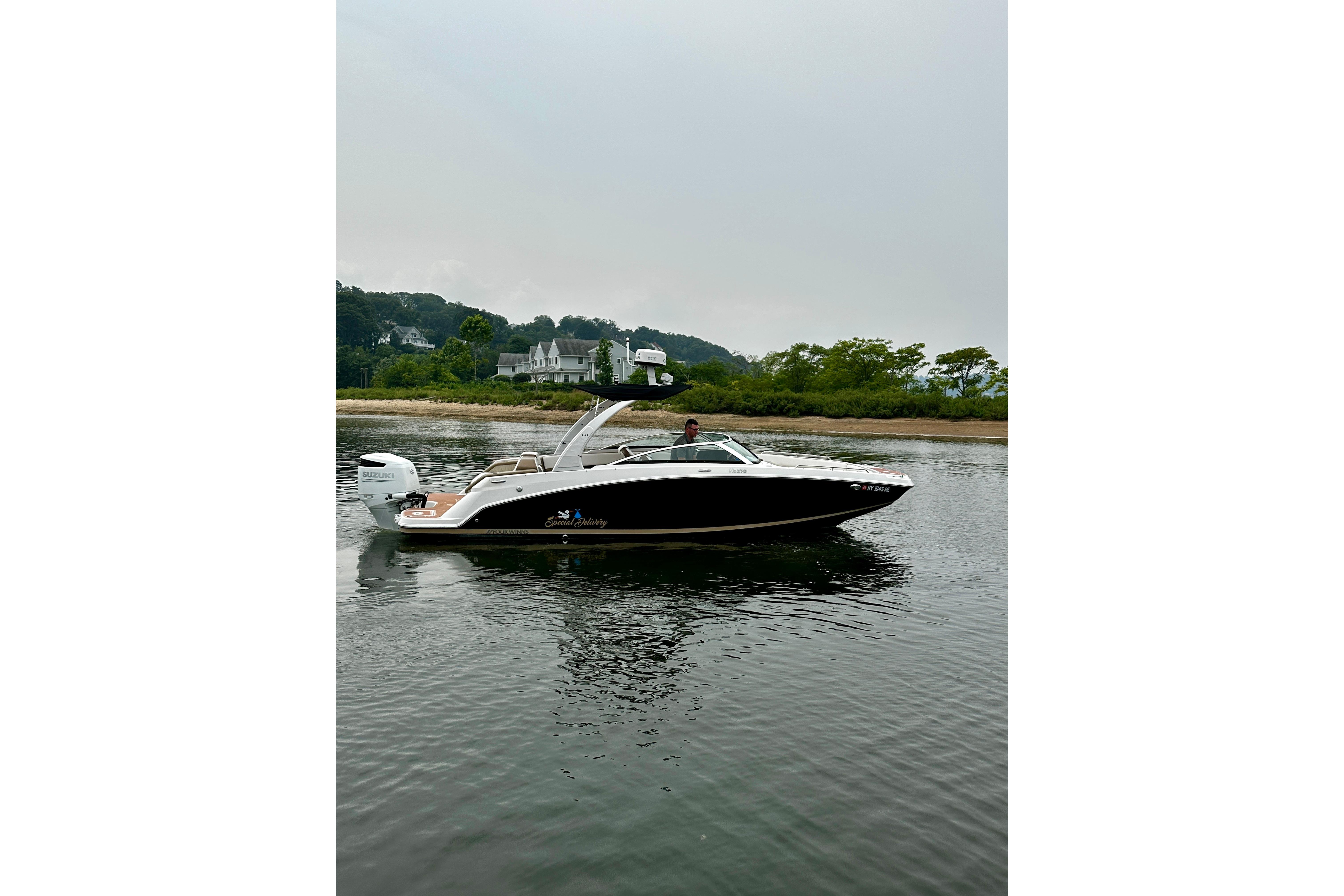 2016 Four Winns Ho270 boat on calm water near a scenic shoreline.