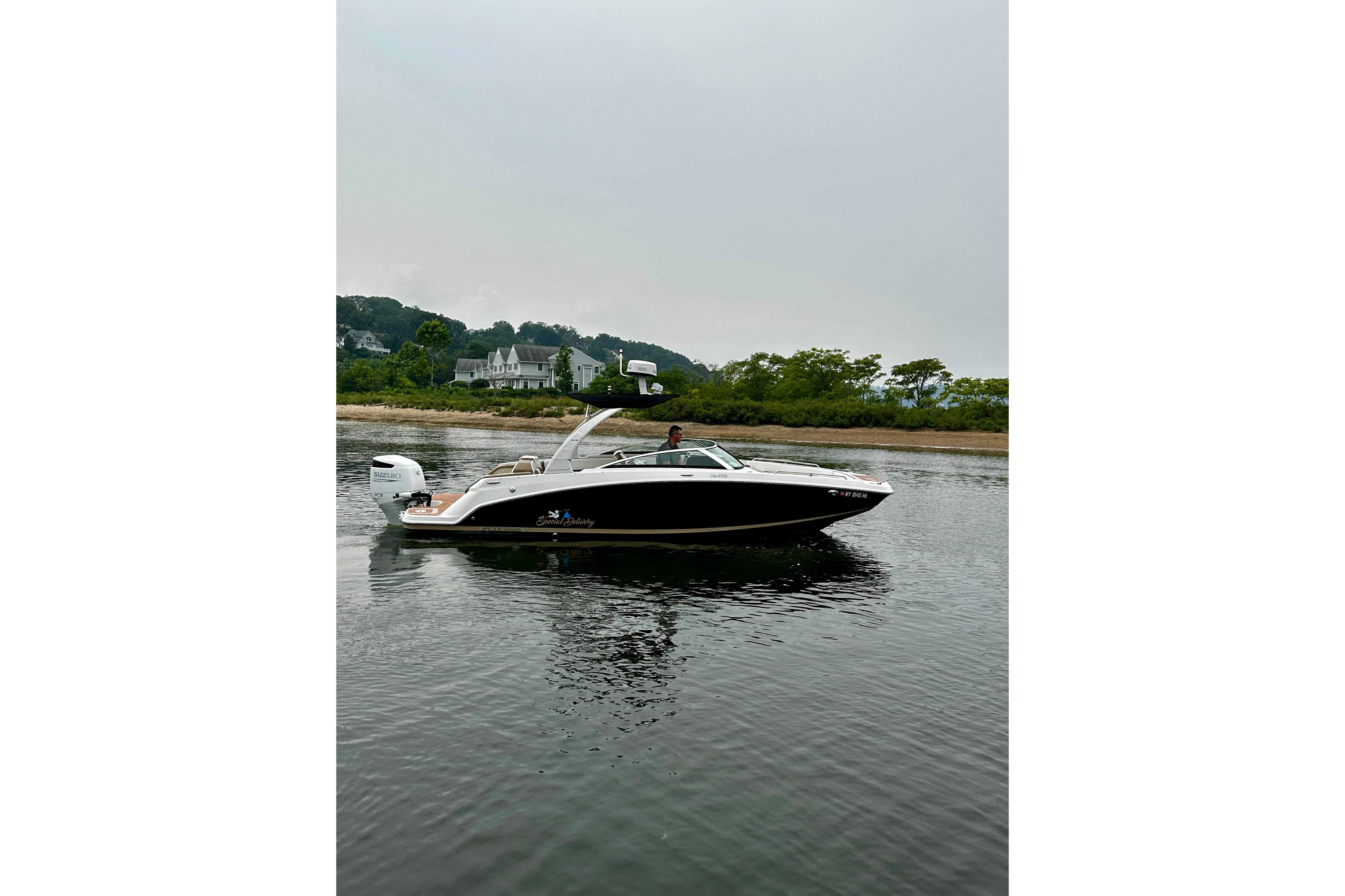 2016 Four Winns Ho270 boat on calm water near a shoreline with trees.