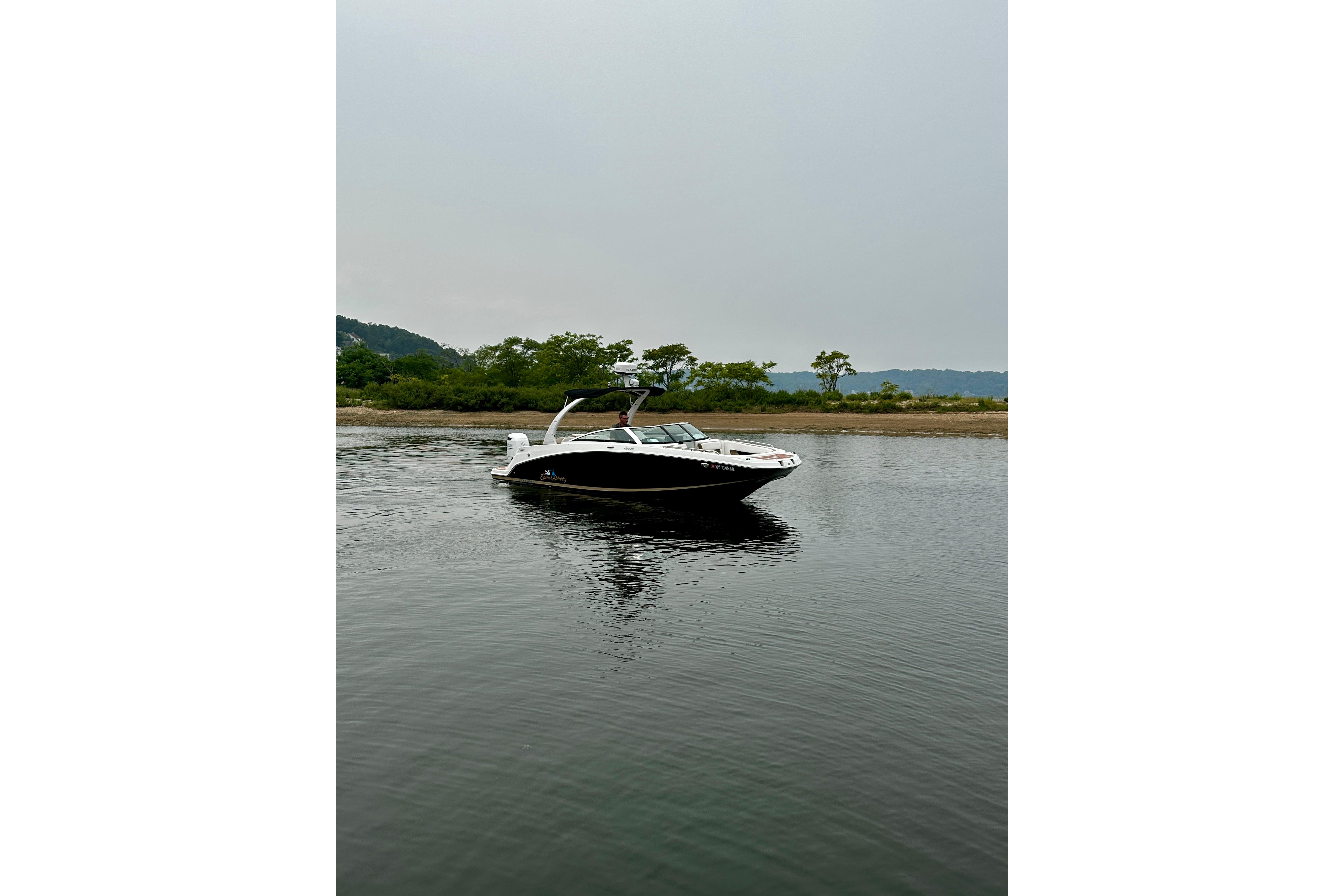 2016 Four Winns Ho270 boat on calm water with scenic background.