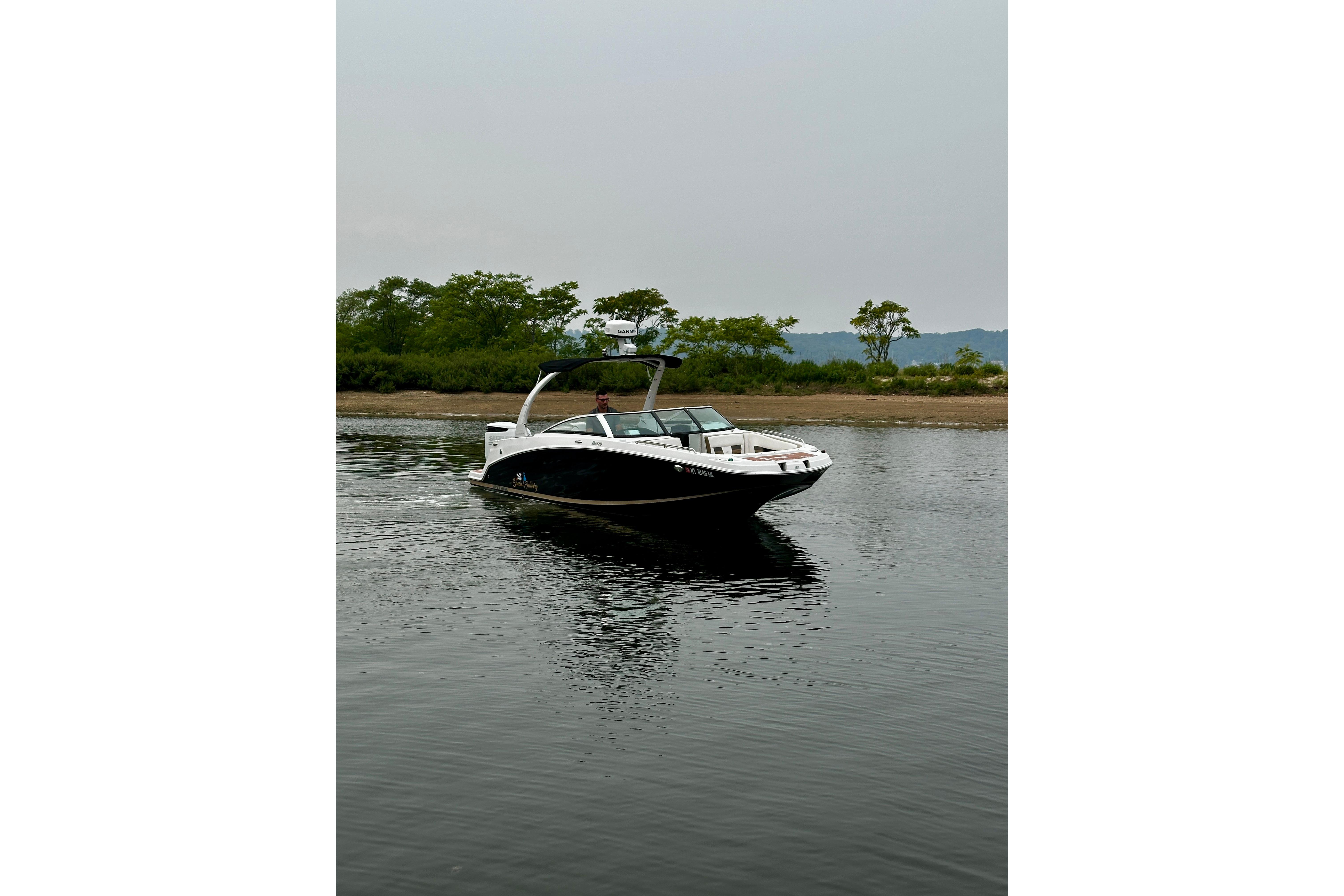 2016 Four Winns Ho270 boat on calm water with lush green shoreline.