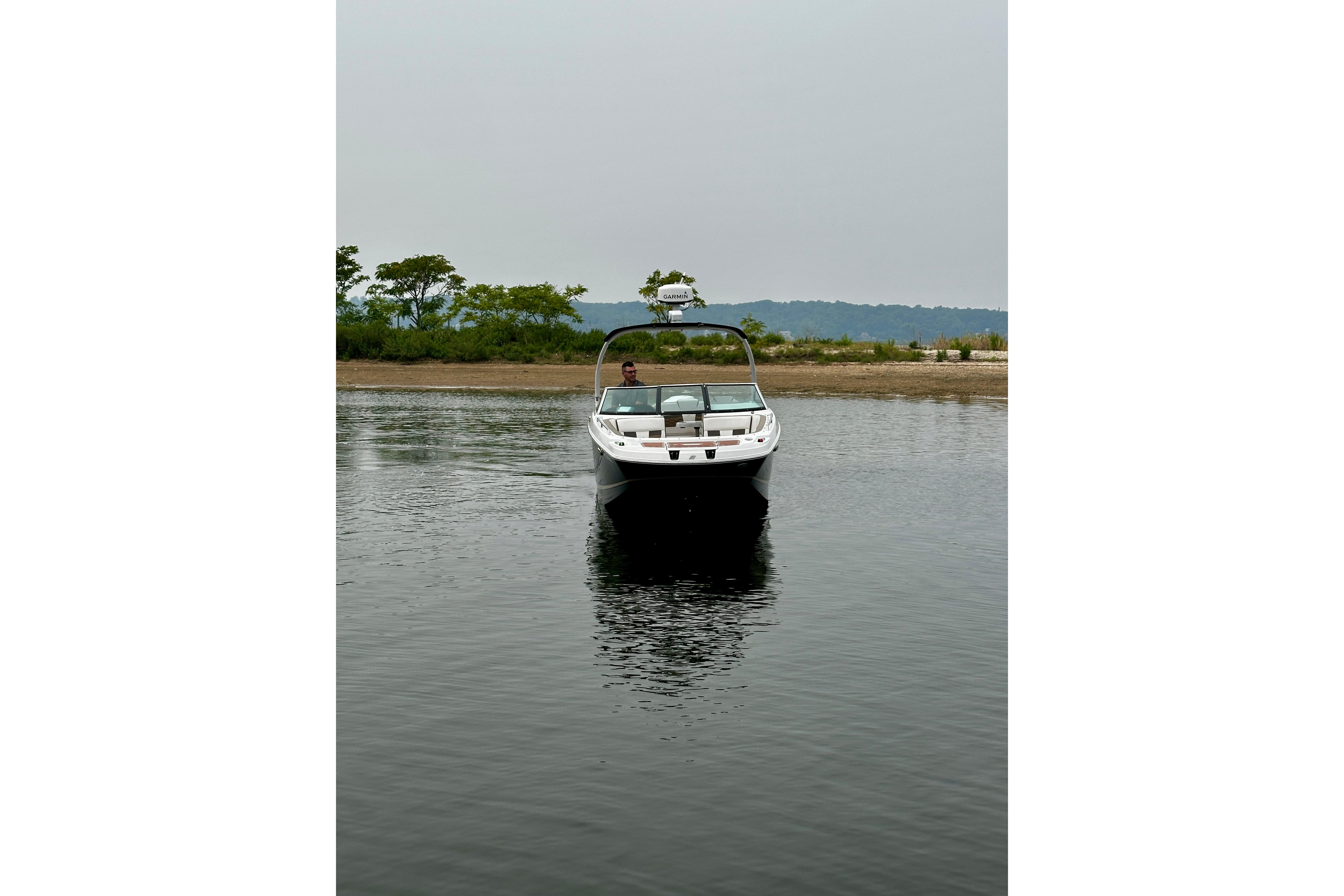 2016 Four Winns Ho270 boat on calm water near shoreline.