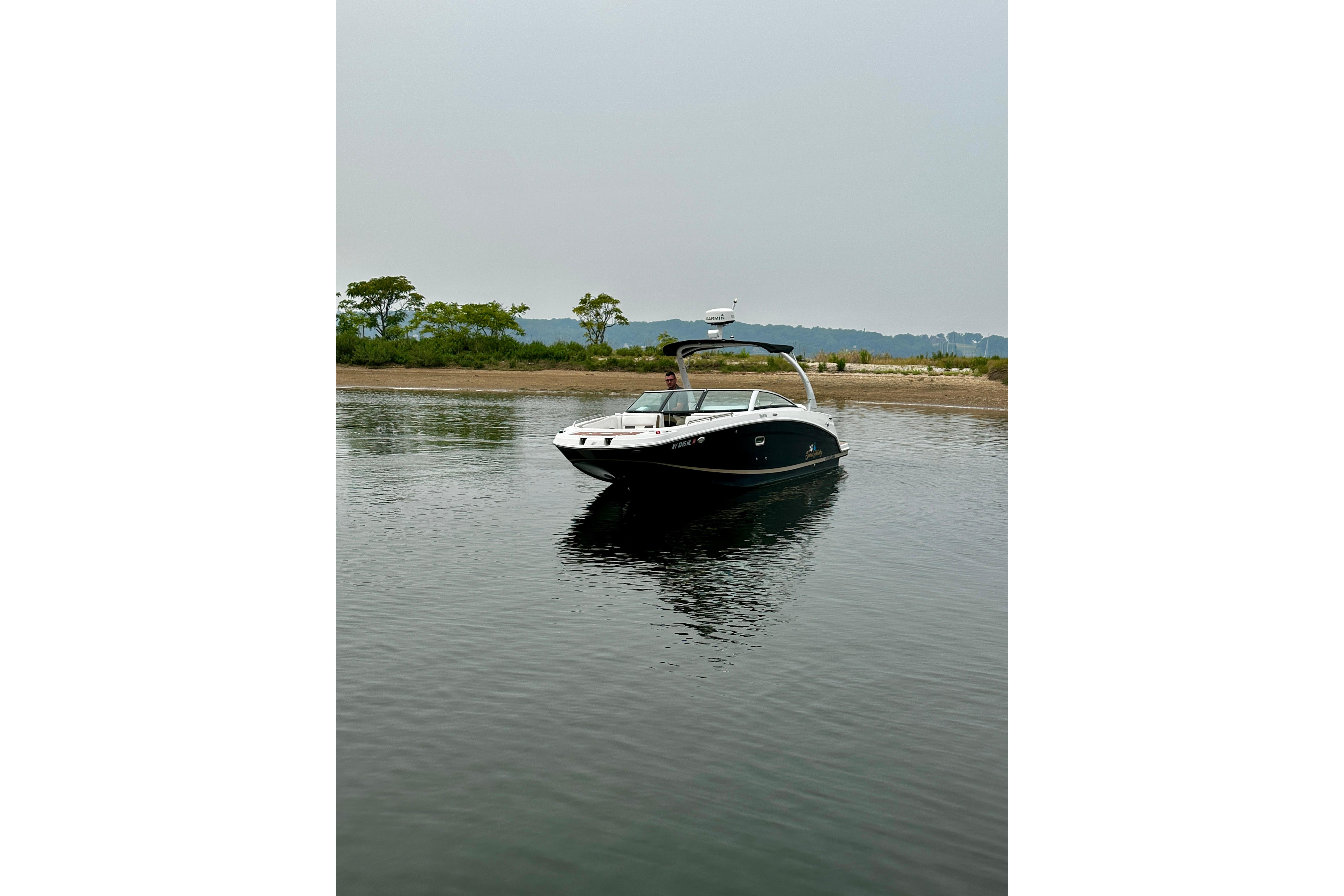 2016 Four Winns Ho270 boat on calm water near a shoreline.