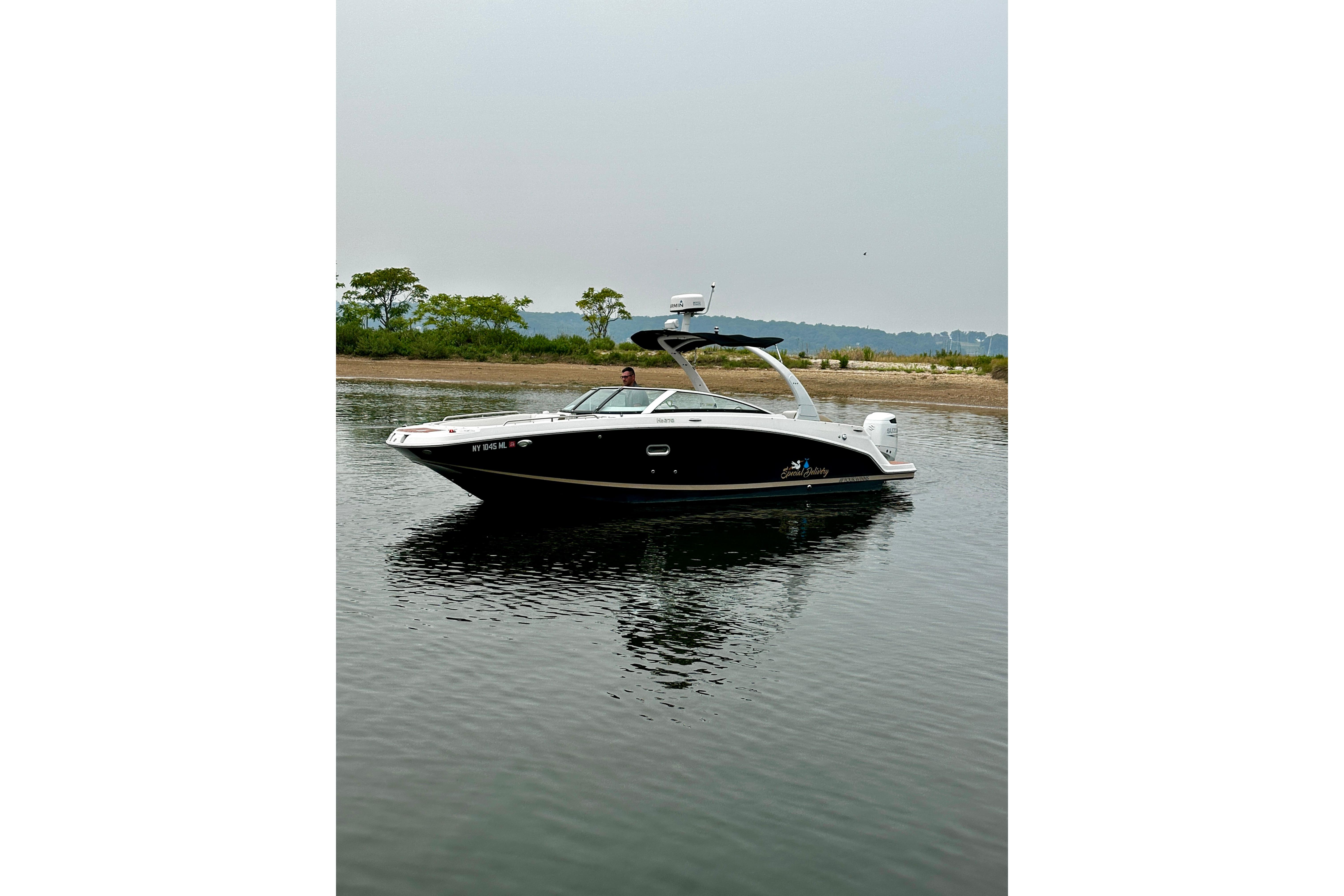 2016 Four Winns Ho270 boat on calm water near a shoreline.