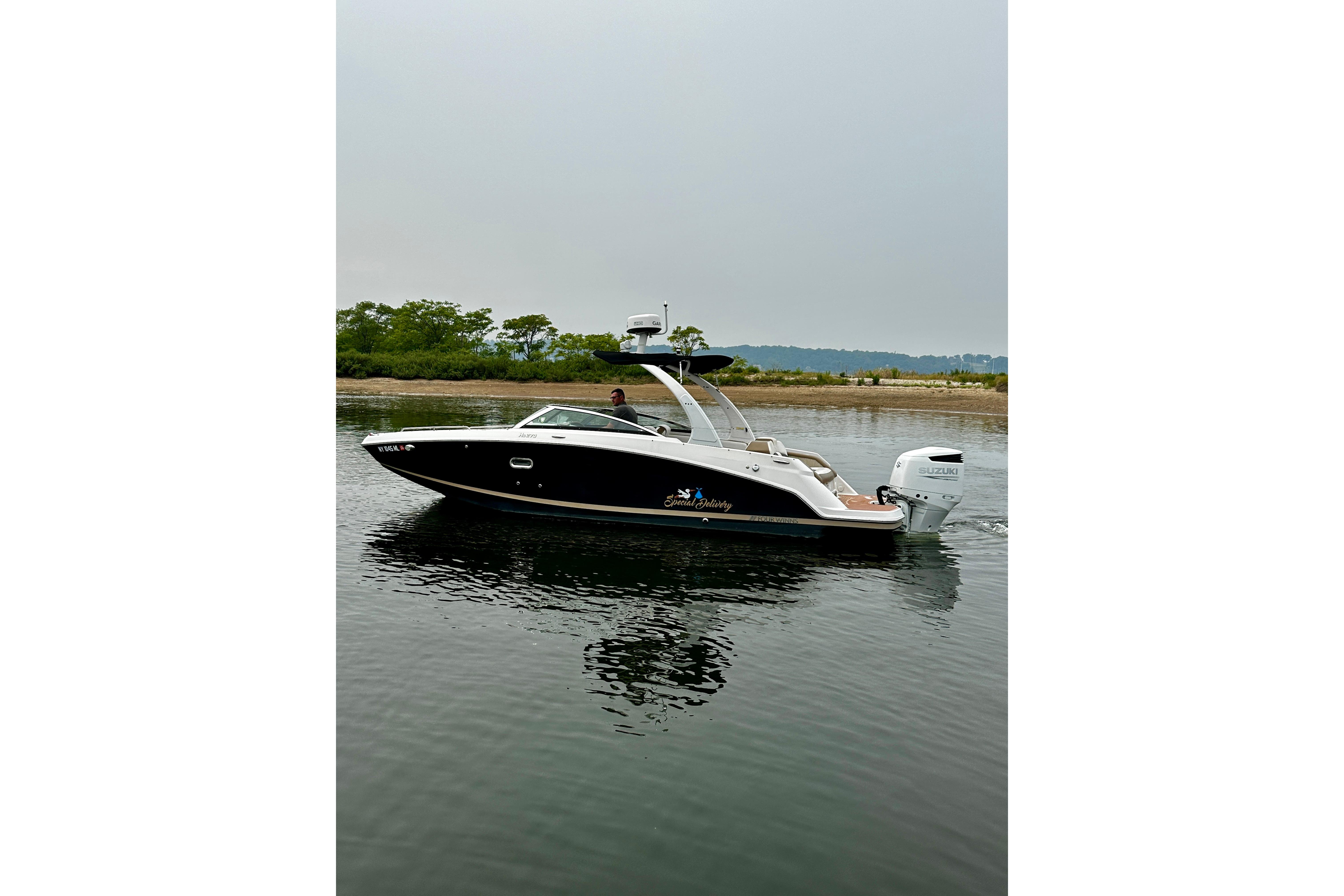 2016 Four Winns Ho270 boat on calm water with scenic background.
