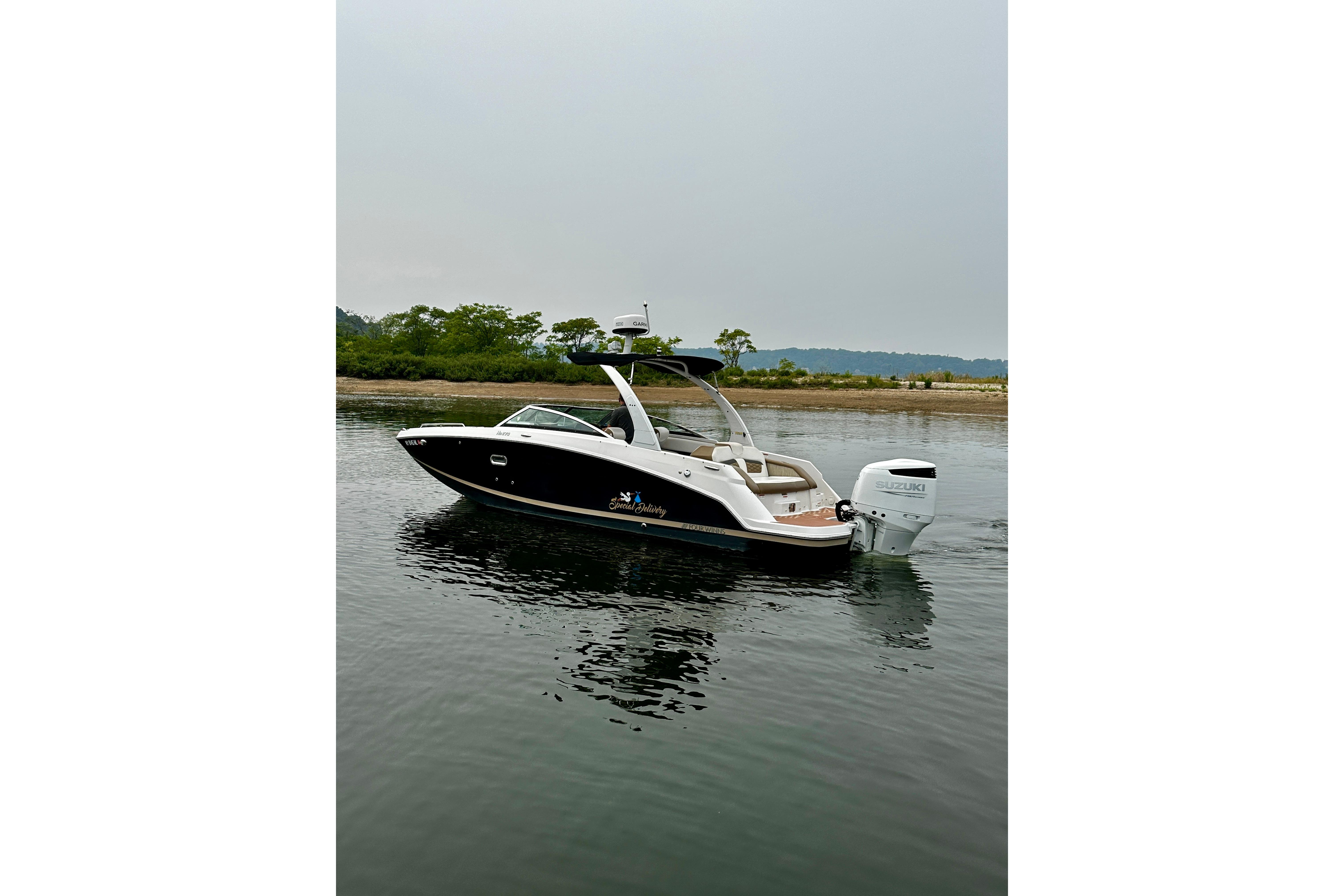 2016 Four Winns Ho270 boat on calm water near a shoreline.