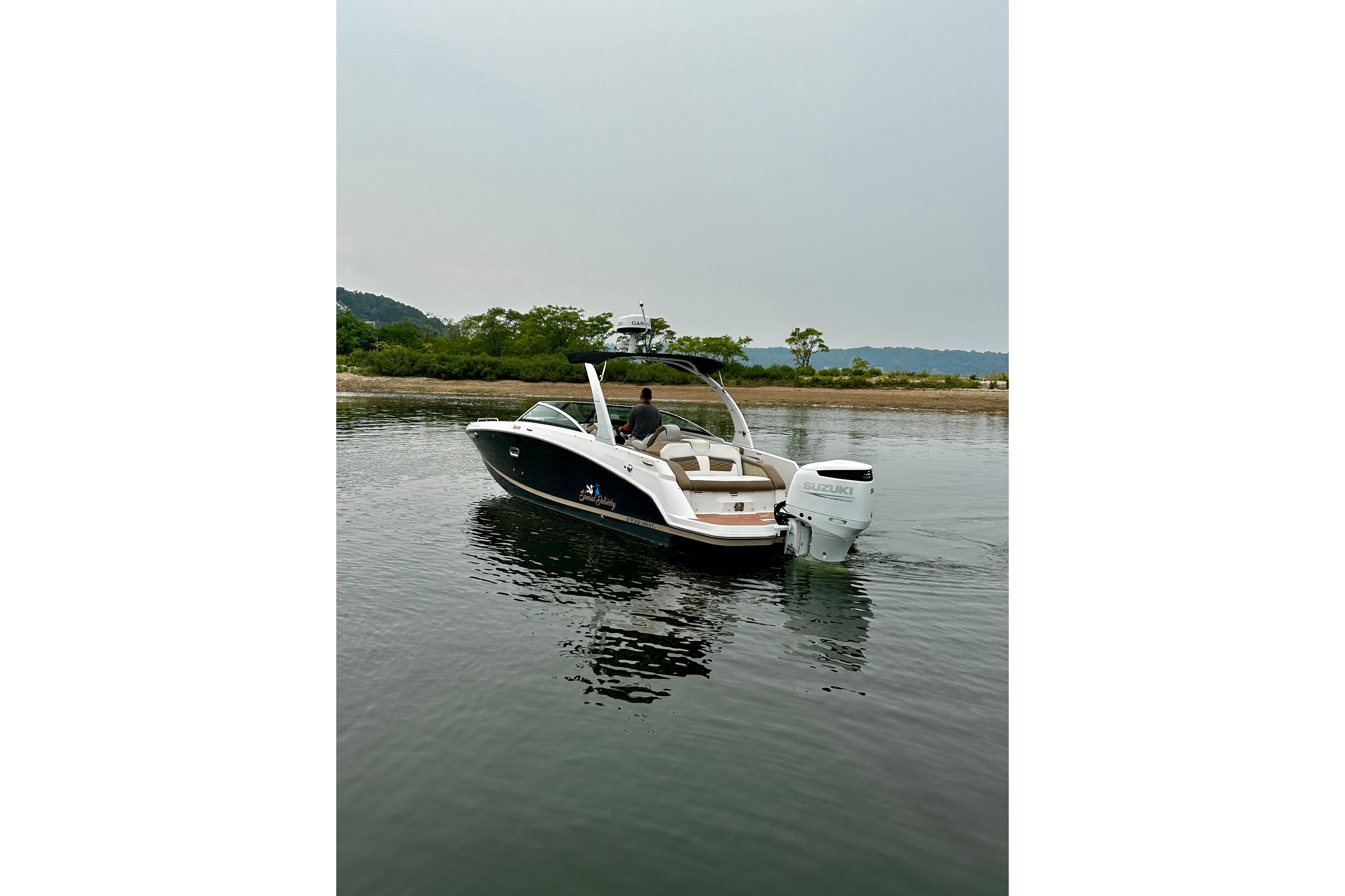 2016 Four Winns Ho270 boat on calm water near a scenic shoreline.
