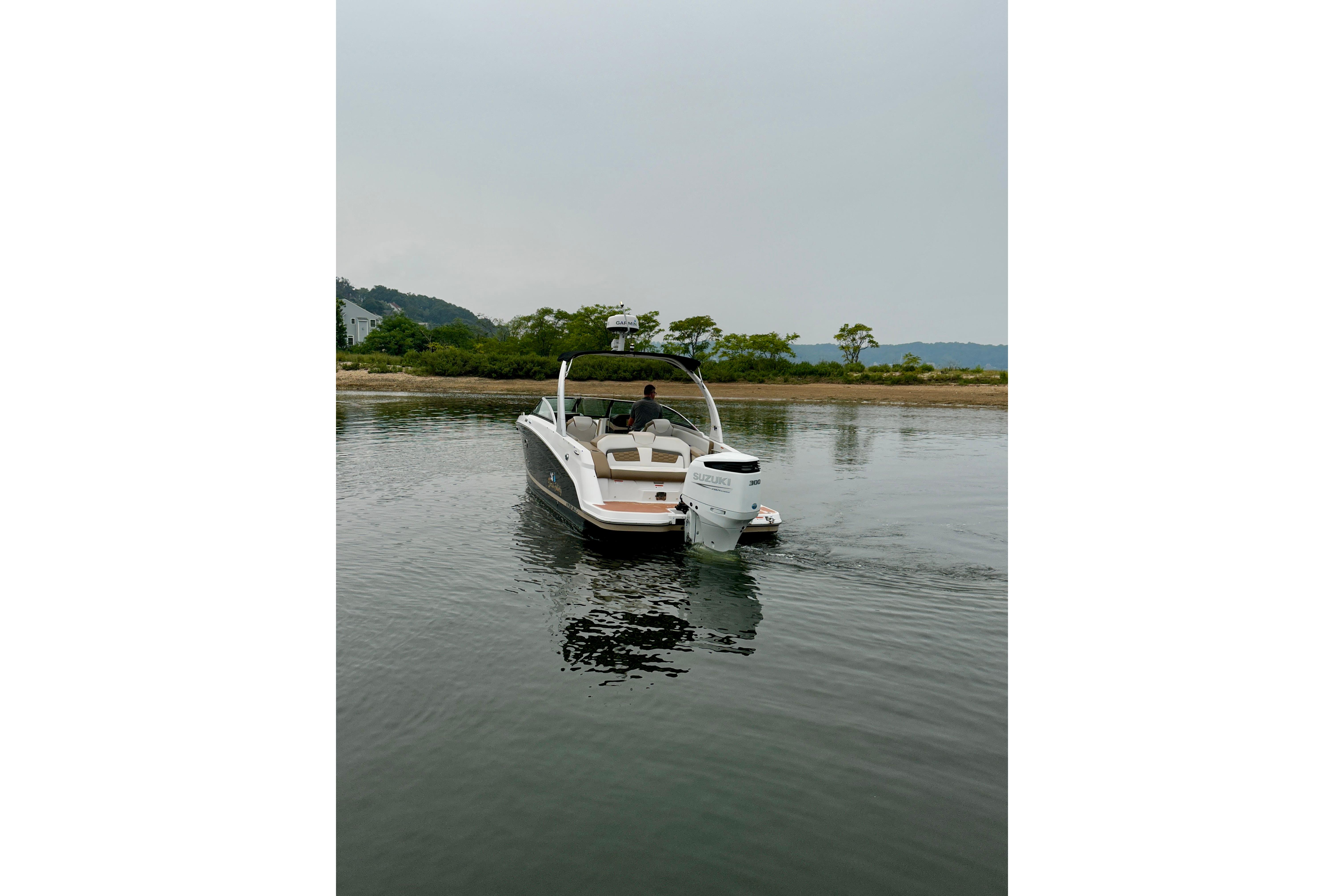 2016 Four Winns Ho270 boat on calm water near a shoreline.