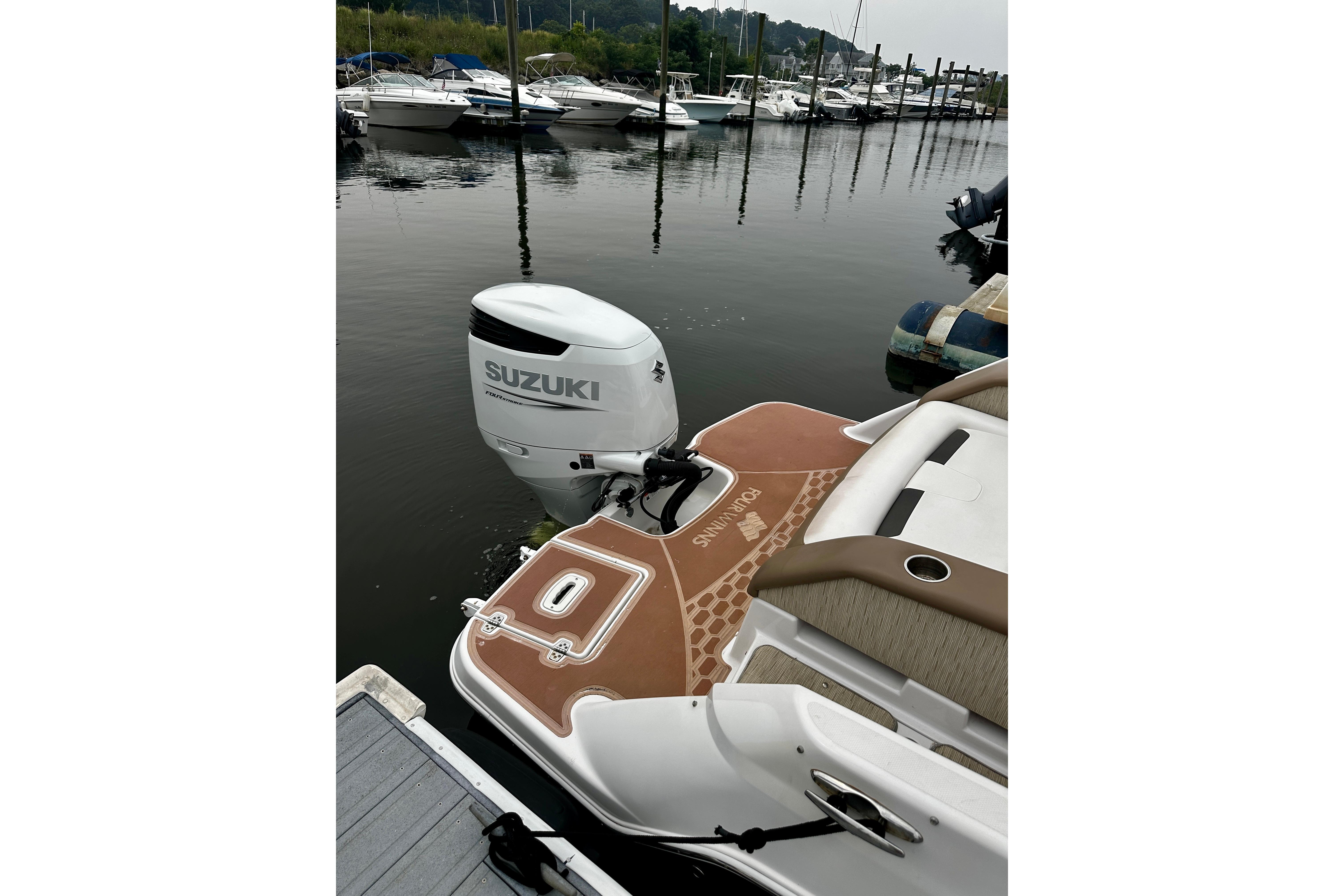 2016 Four Winns Ho270 boat with Suzuki outboard motor docked at marina.