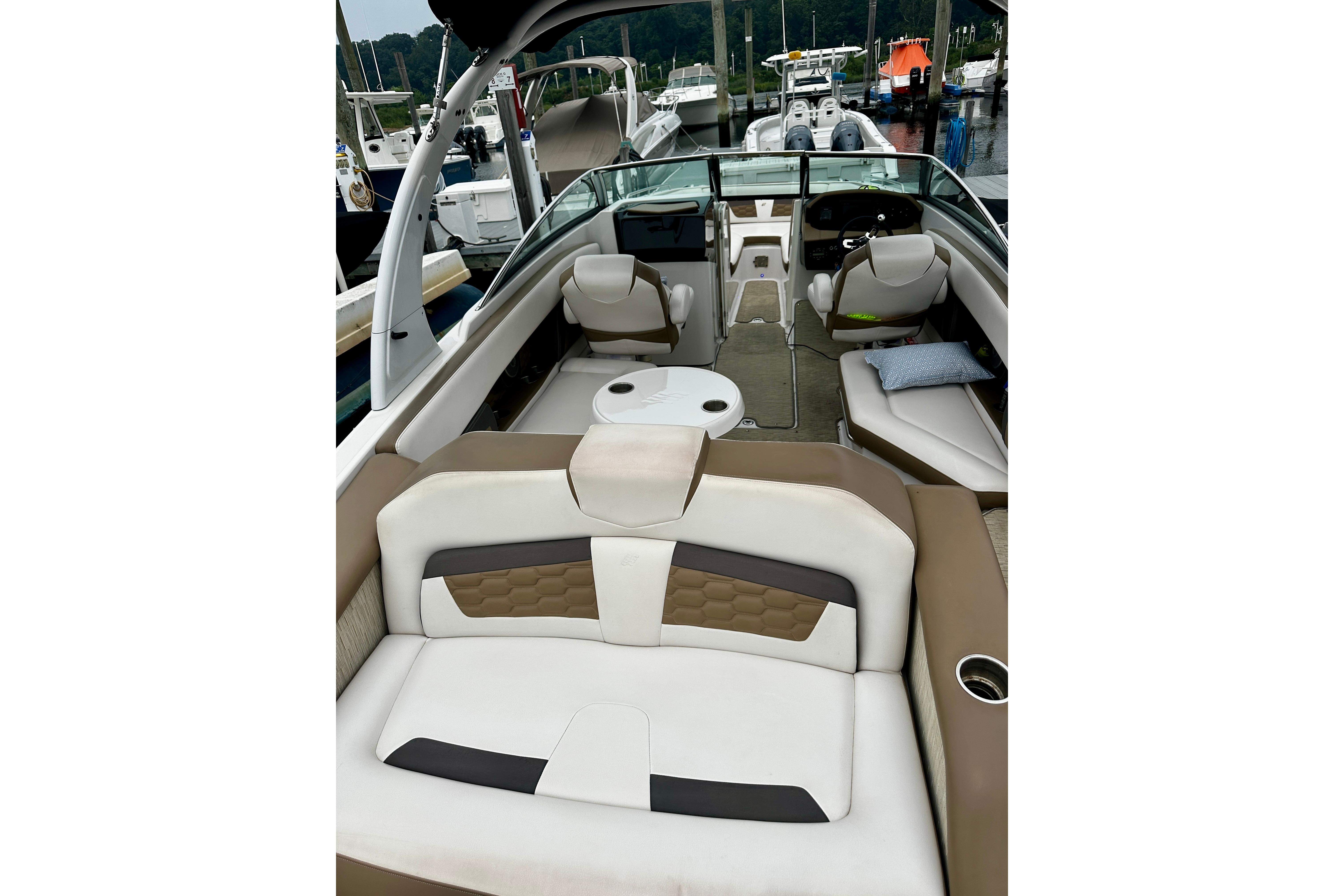 2016 Four Winns Ho270 boat interior with seating and helm, docked at marina.
