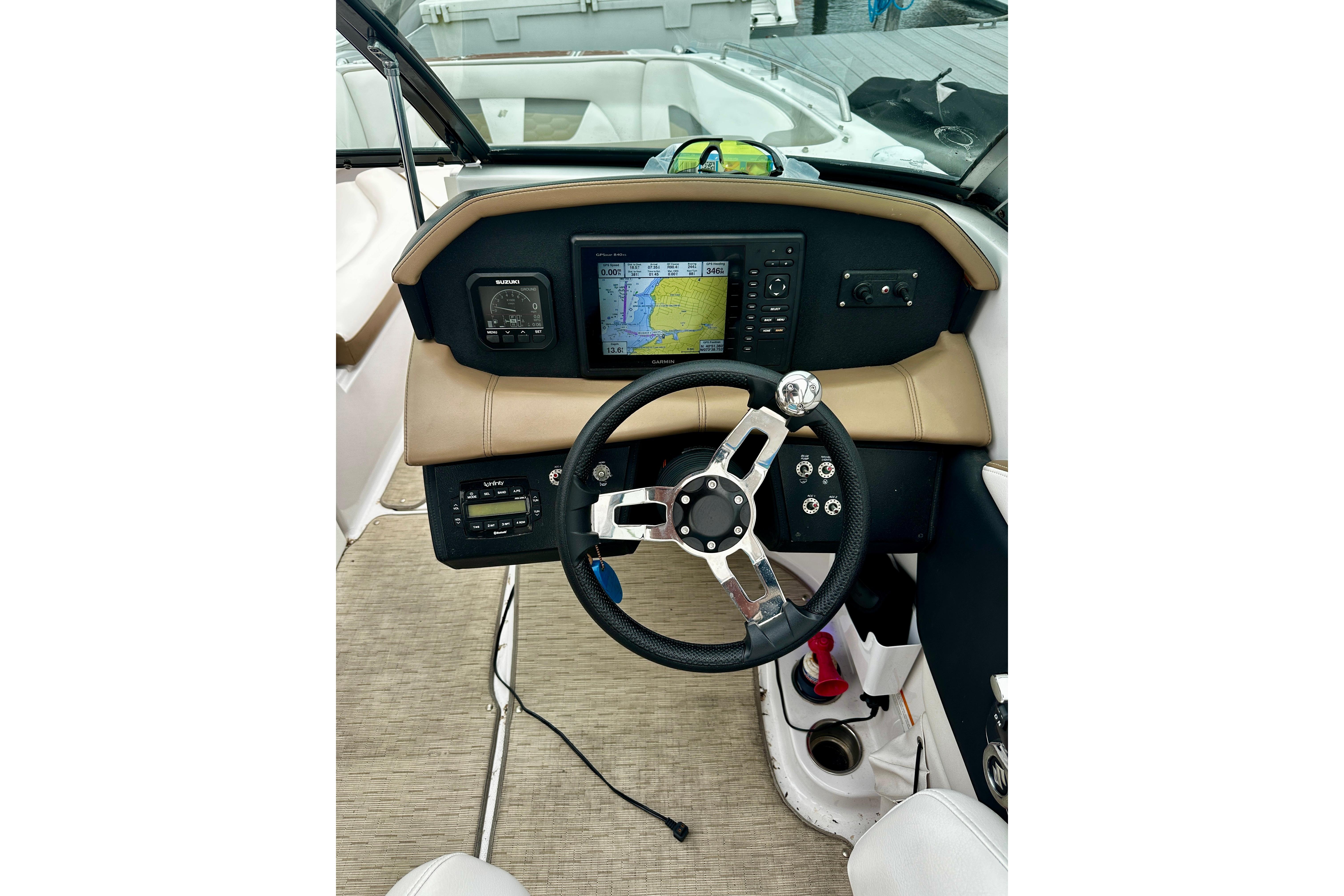 2016 Four Winns Ho270 boat dashboard with steering wheel and navigation display.