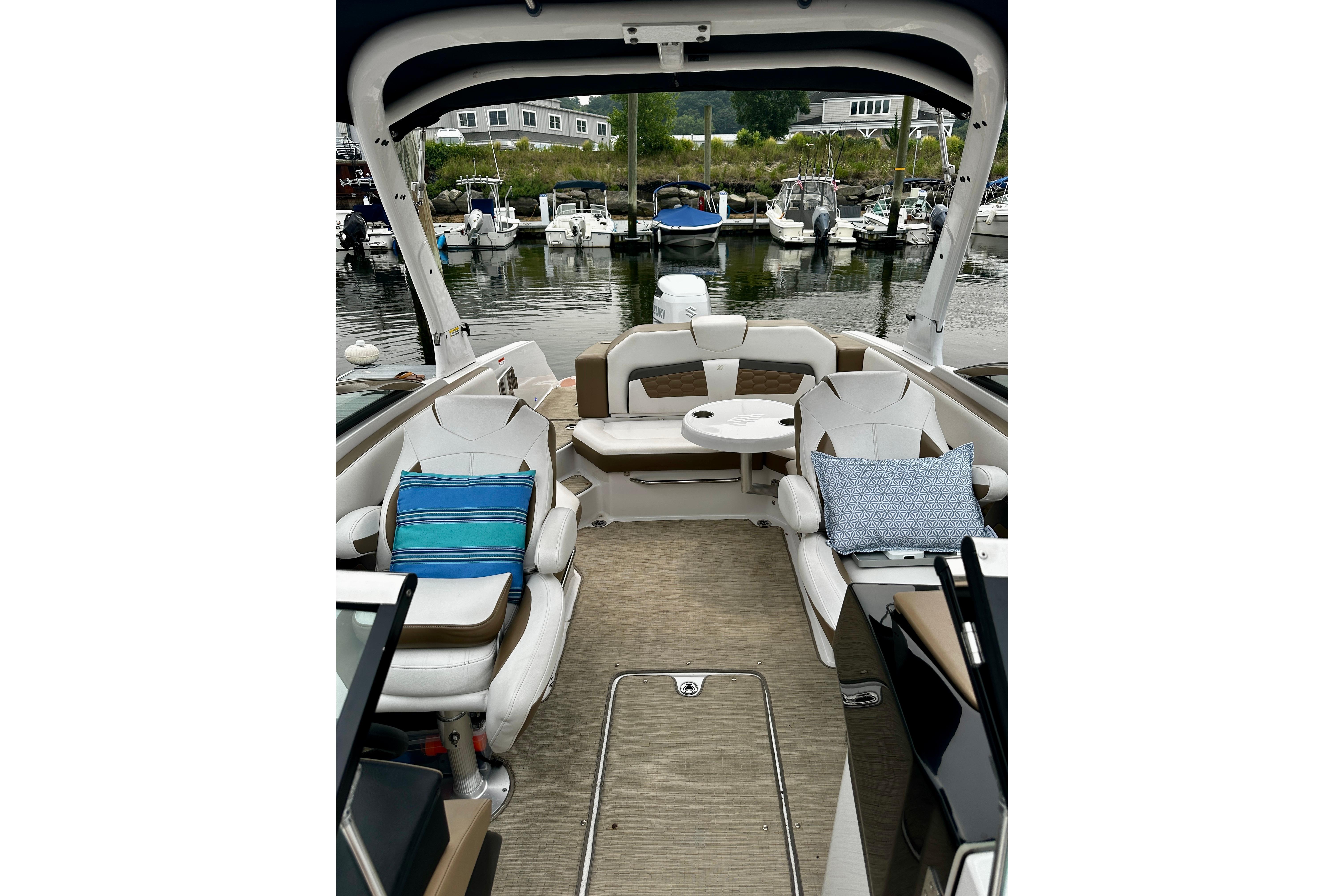 2016 Four Winns Ho270 boat interior with seating and cushions at a marina.