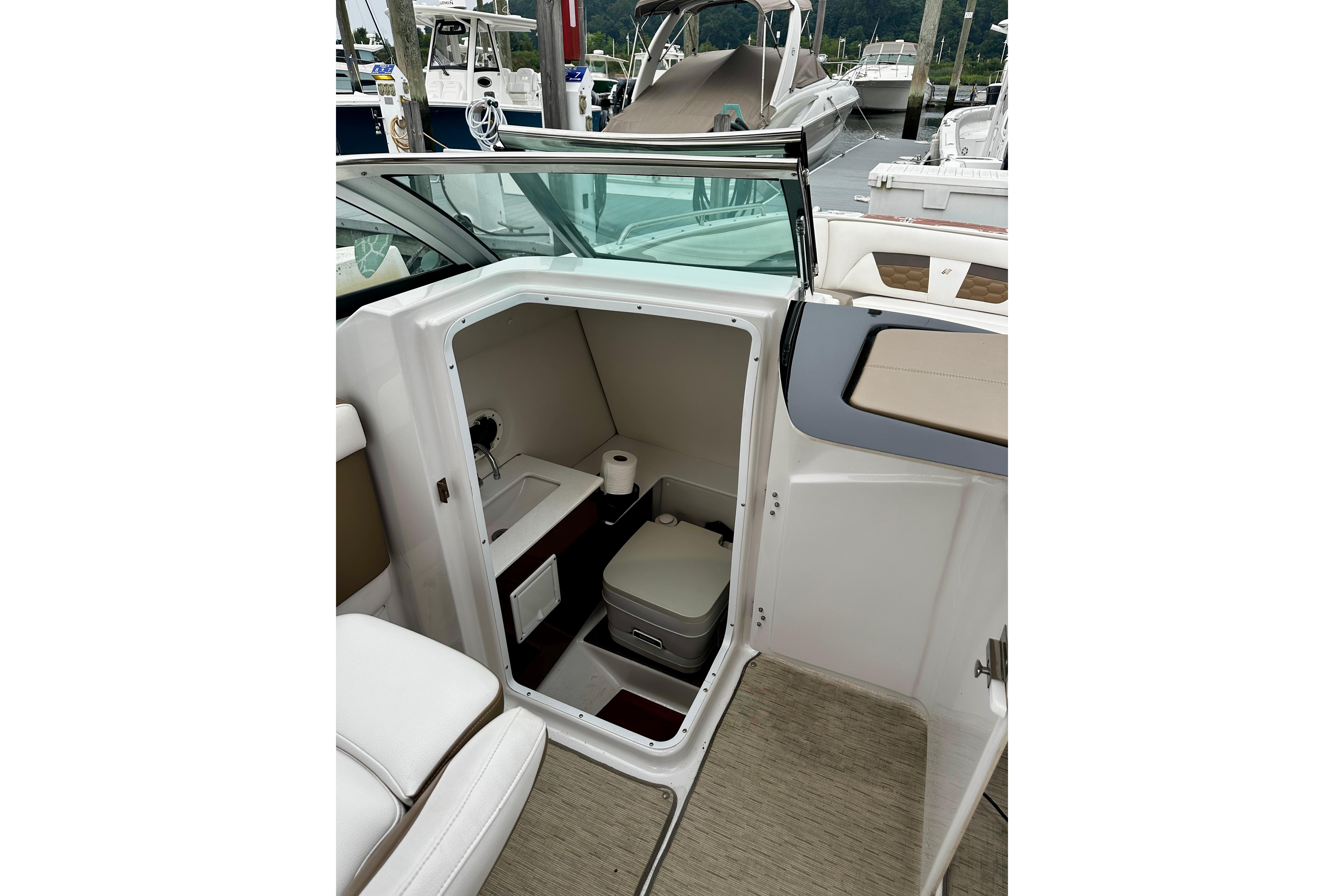2016 Four Winns Ho270 boat interior with compact bathroom and seating area.