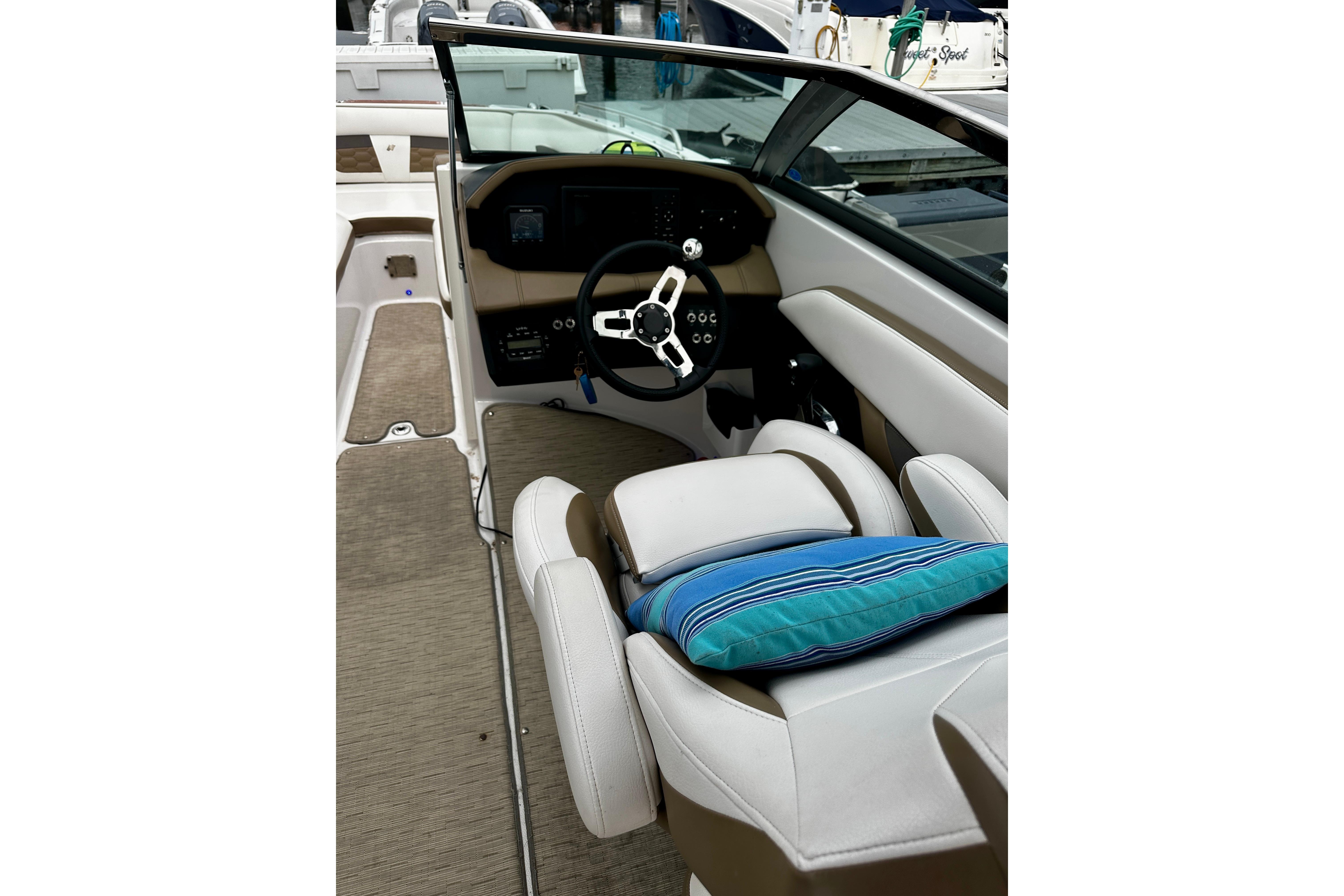 2016 Four Winns Ho270 boat interior with steering wheel and cushioned seating.
