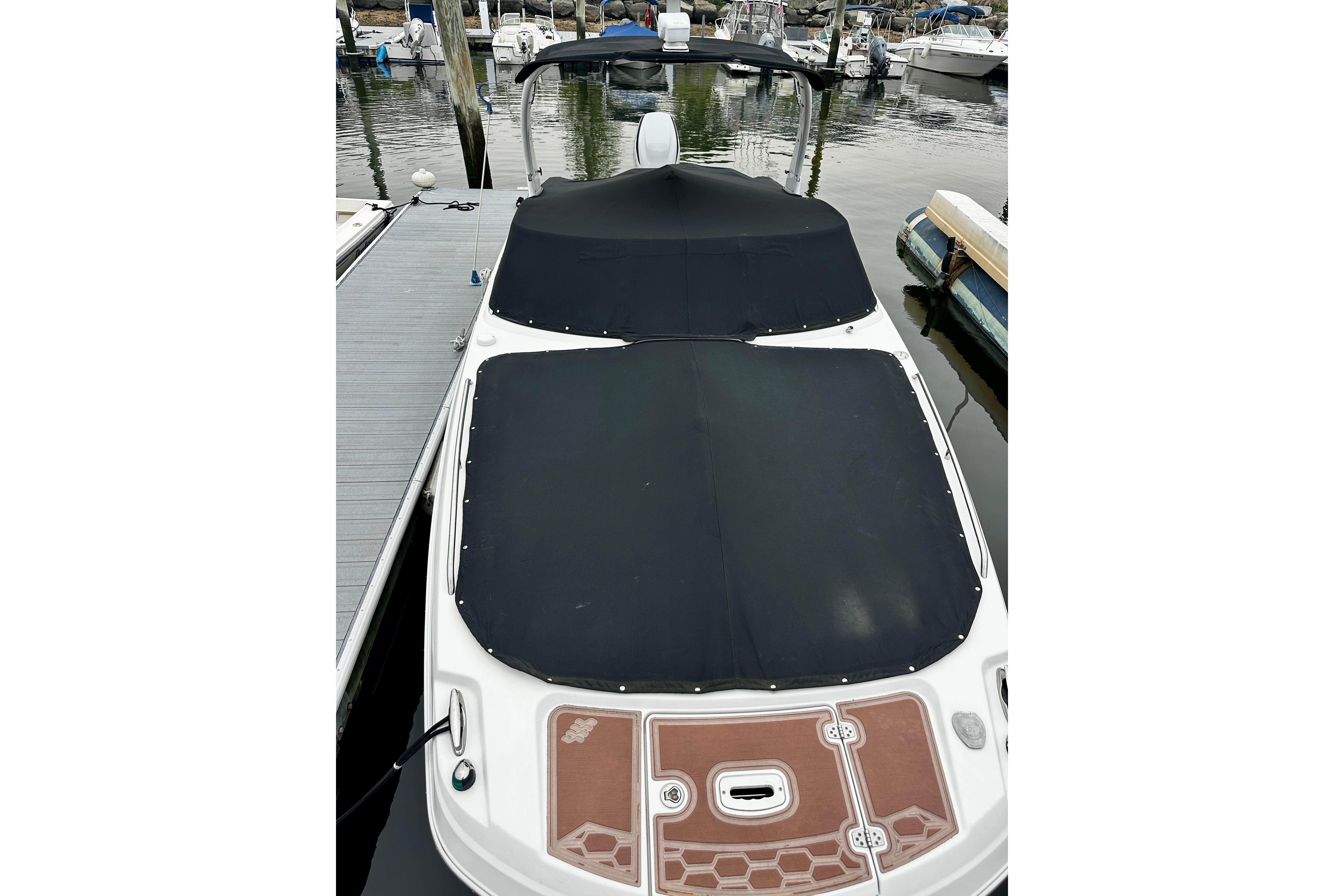 2016 Four Winns Ho270 boat with black covers docked at marina.