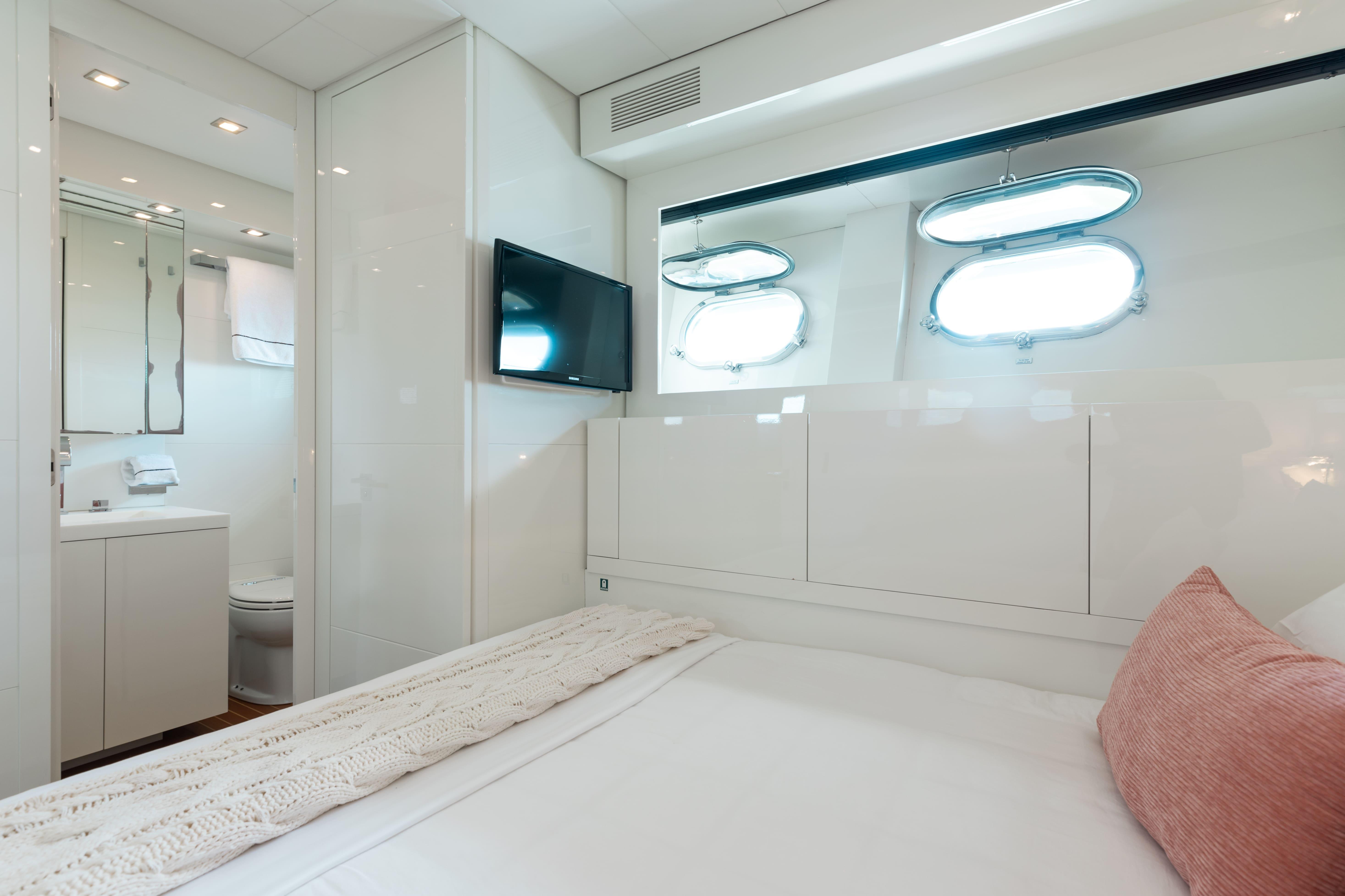 Leopard-Cantiere Navale Arno SpA 2007-VENTURE FL-US-Luxurious yacht bedroom with ensuite bathroom, featuring modern decor and porthole windows, Leopard 2007 model.-9232651 | Thumbnail