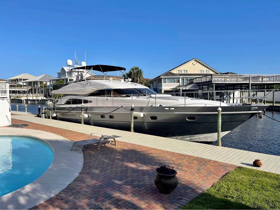 Luxury 2003 Viking Princess 65 yacht docked by a poolside, under clear blue skies.