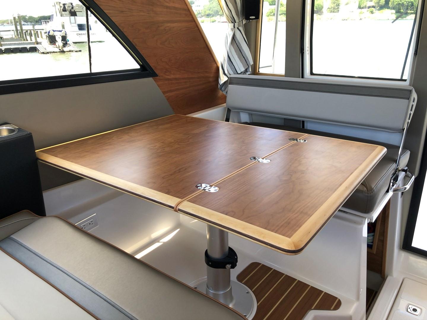 Picture of C32 CB 2025 Cutwater 37.67 ft' C-32 CB Interior of 2025 Cutwater C-32 CB boat with wooden dining table and seating. 