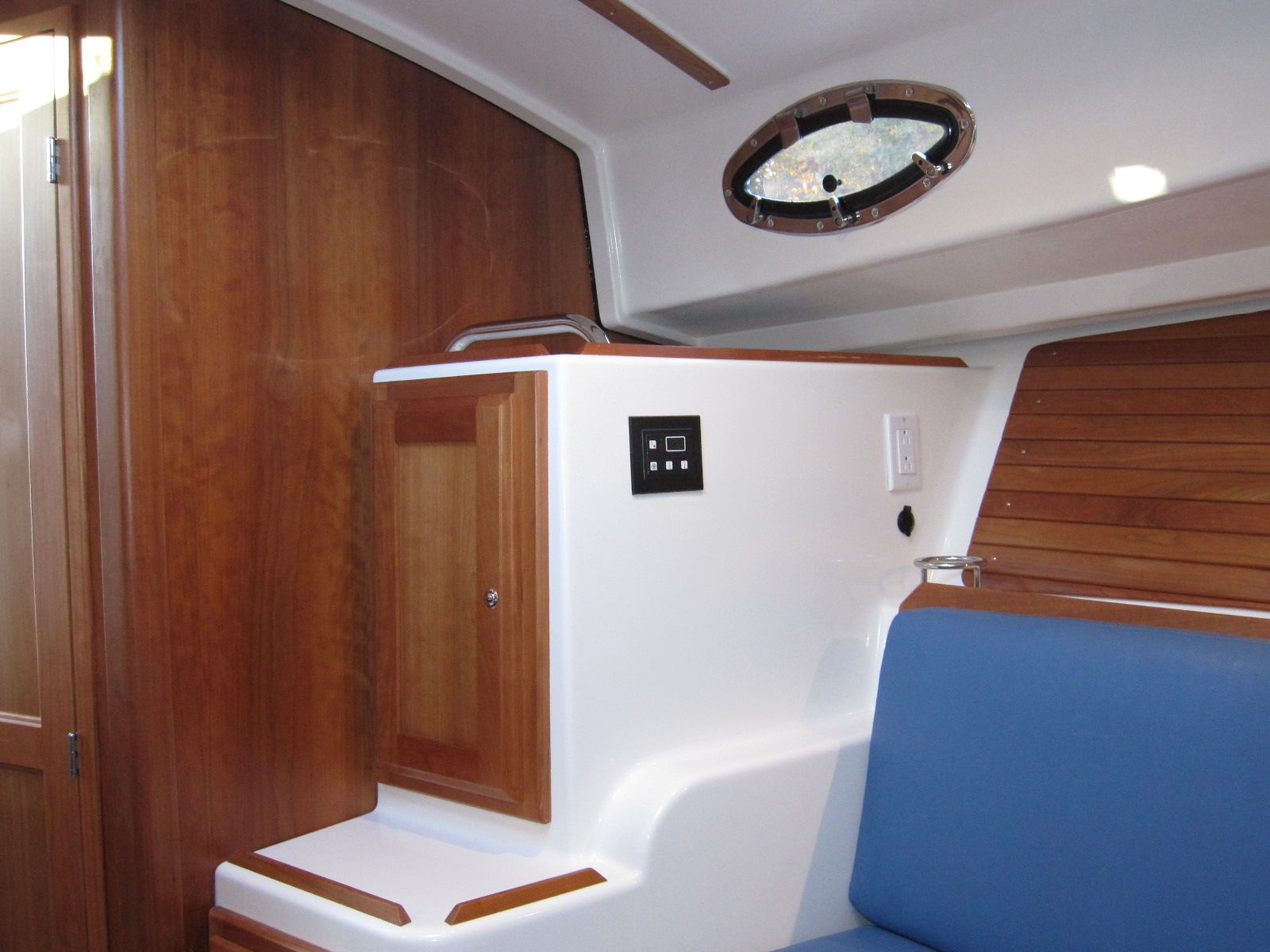 Interior of 2011 Back Cove 30 boat with wood paneling and blue seating.